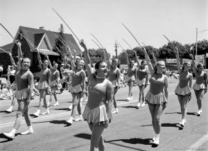 Cyprus High School Spinnakers drill team march with sabres at the 4th of July parade on Main Street.