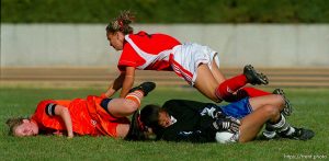 Alta goalkeeper Megan Mills (right) clutches the ball after taking it away from Brighton's Tara Bennion (left) during Saturday's 5A State Championship game. Alta defender Ashley Engar is in flight. Alta beats Brighton for 5A State Soccer Championship.