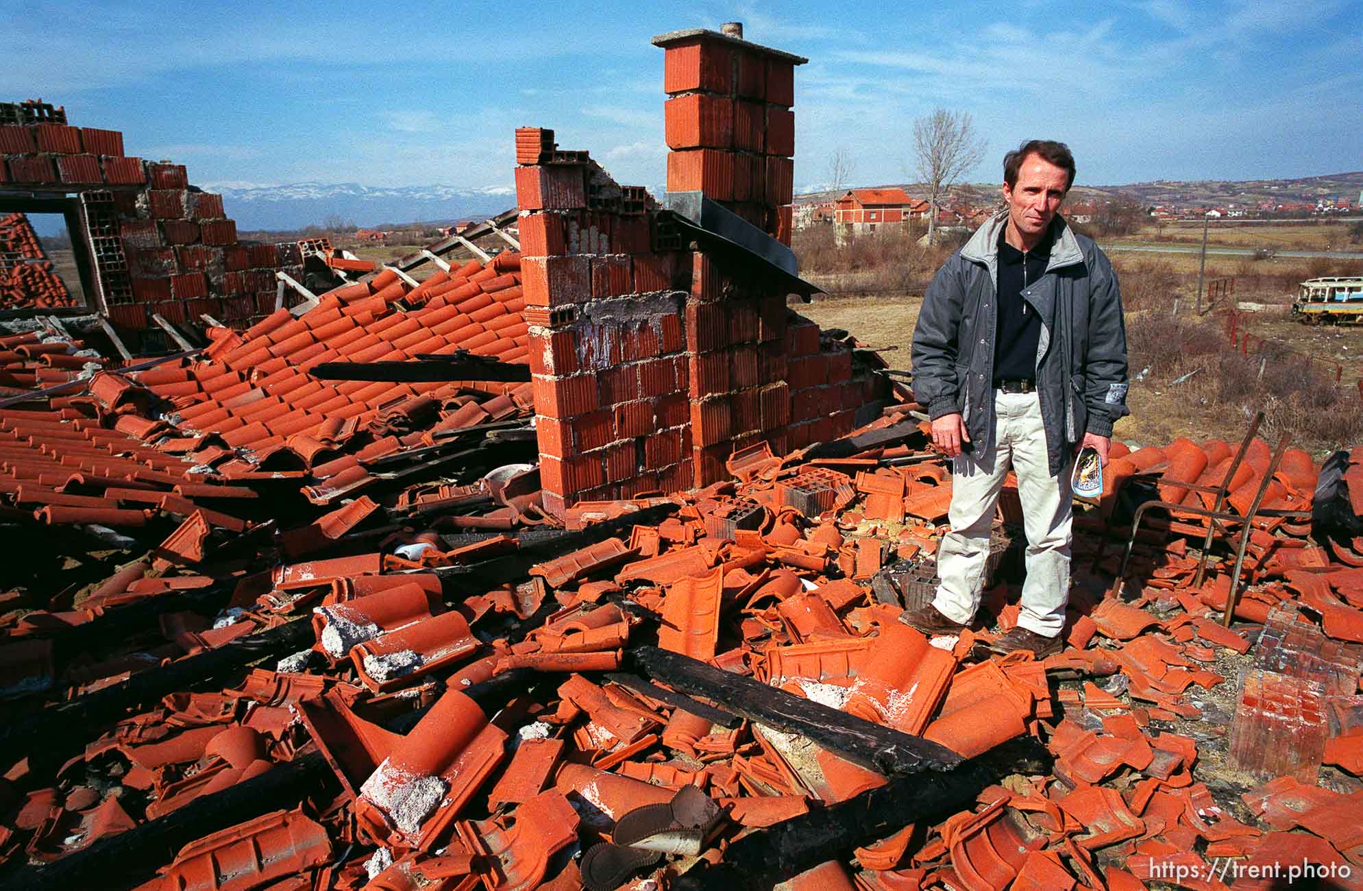 Naim Begiri in the ruins of his uncle's house, where he hid from Serb forces during the war.