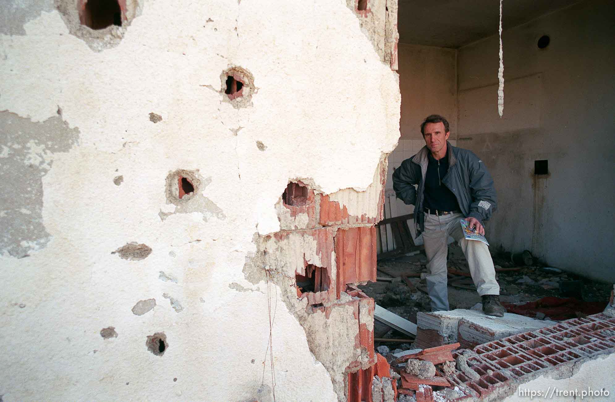 Naim Begiri in the ruins of his uncle's house, where he hid from Serb forces during the war.