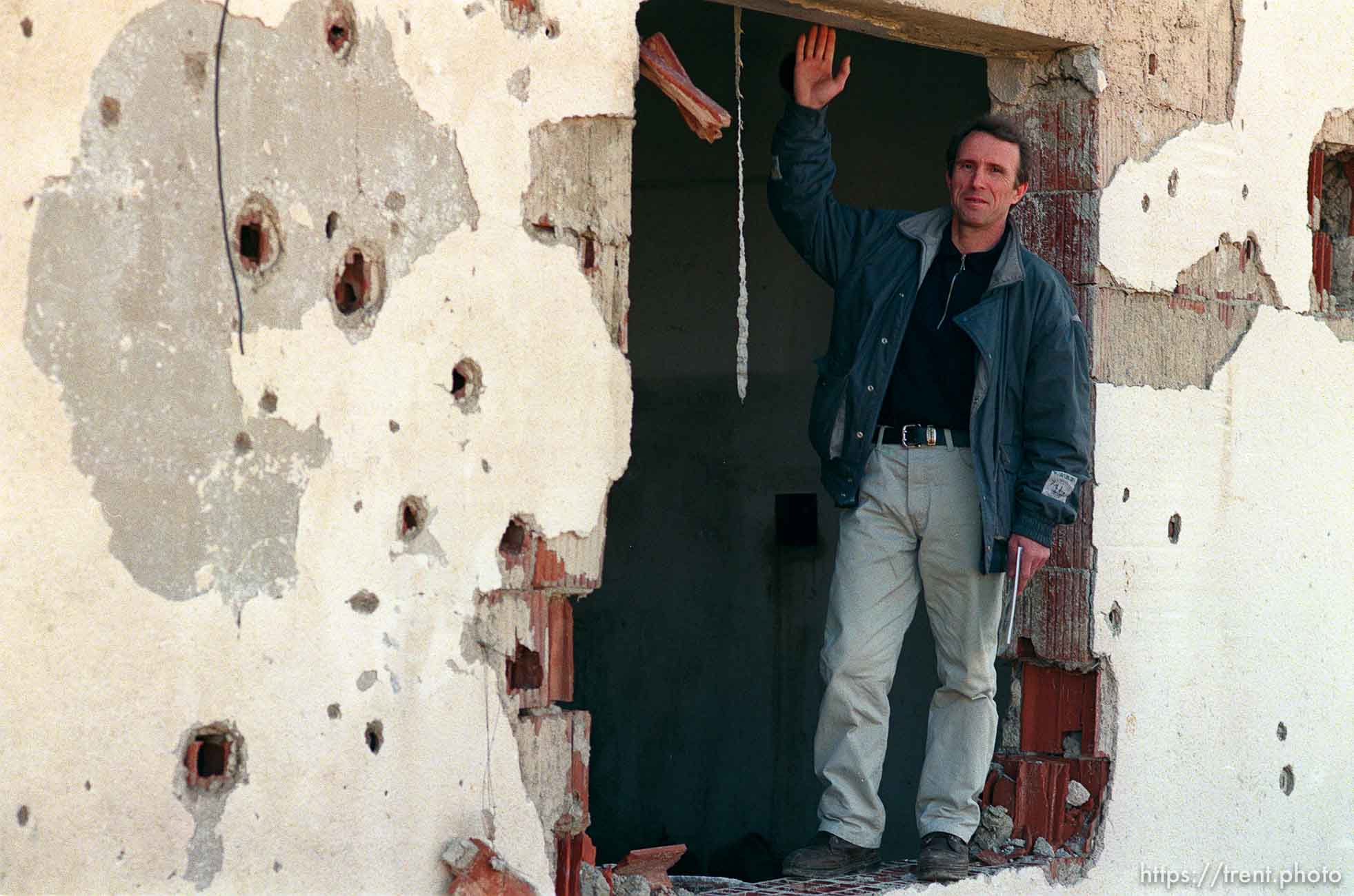 Naim Begiri in the ruins of his uncle's house, where he hid from Serb forces during the war.