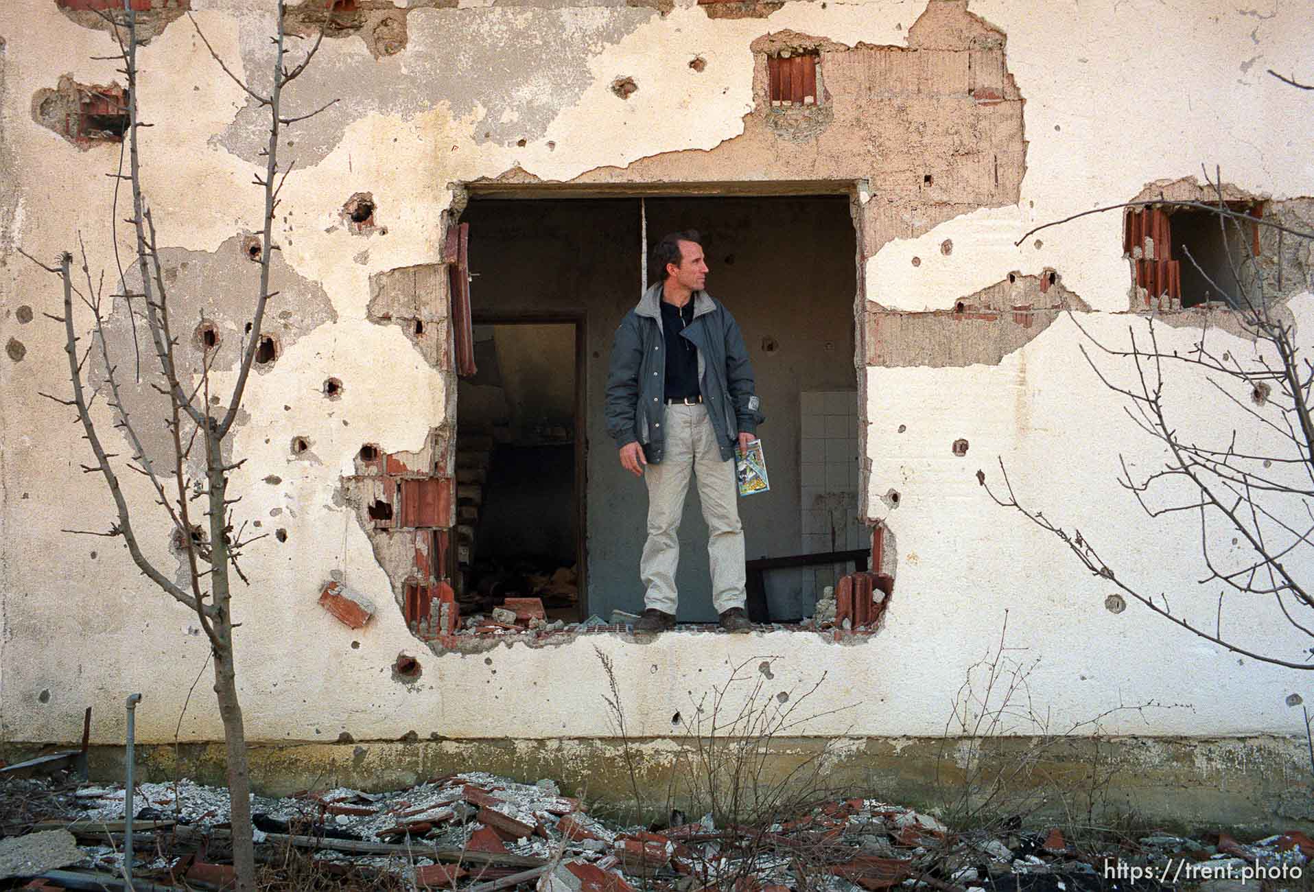 Naim Begiri in the ruins of his uncle's house, where he hid from Serb forces during the war.