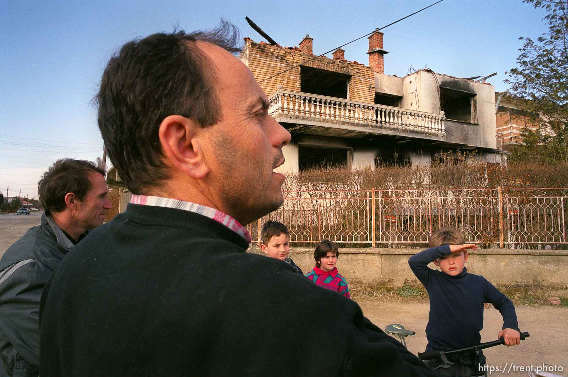 Shkelzen Binxhia talks about his brother's house (in background) which was an OSCE base during the KVM and later burned by Serbs.