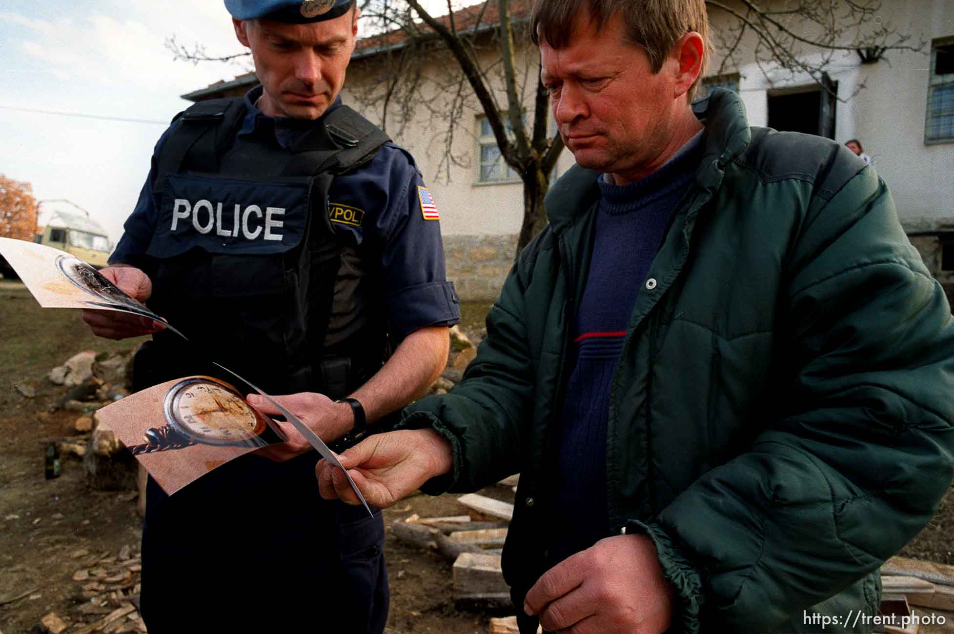 UNMIK police officer Zane Smith shows evidence photos to a Serb in Northern Kosovo, trying to crack a homicide case.