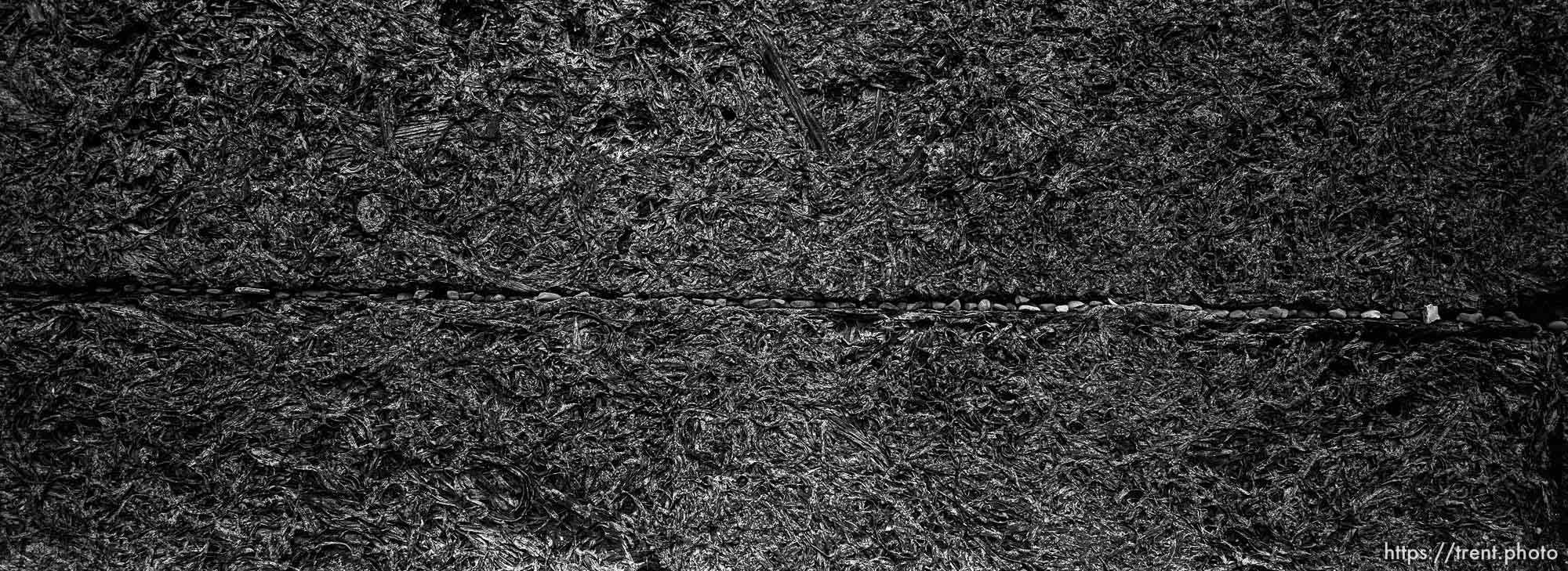 Small stones in the Wall of Death at the Auschwitz Concentration Camp.