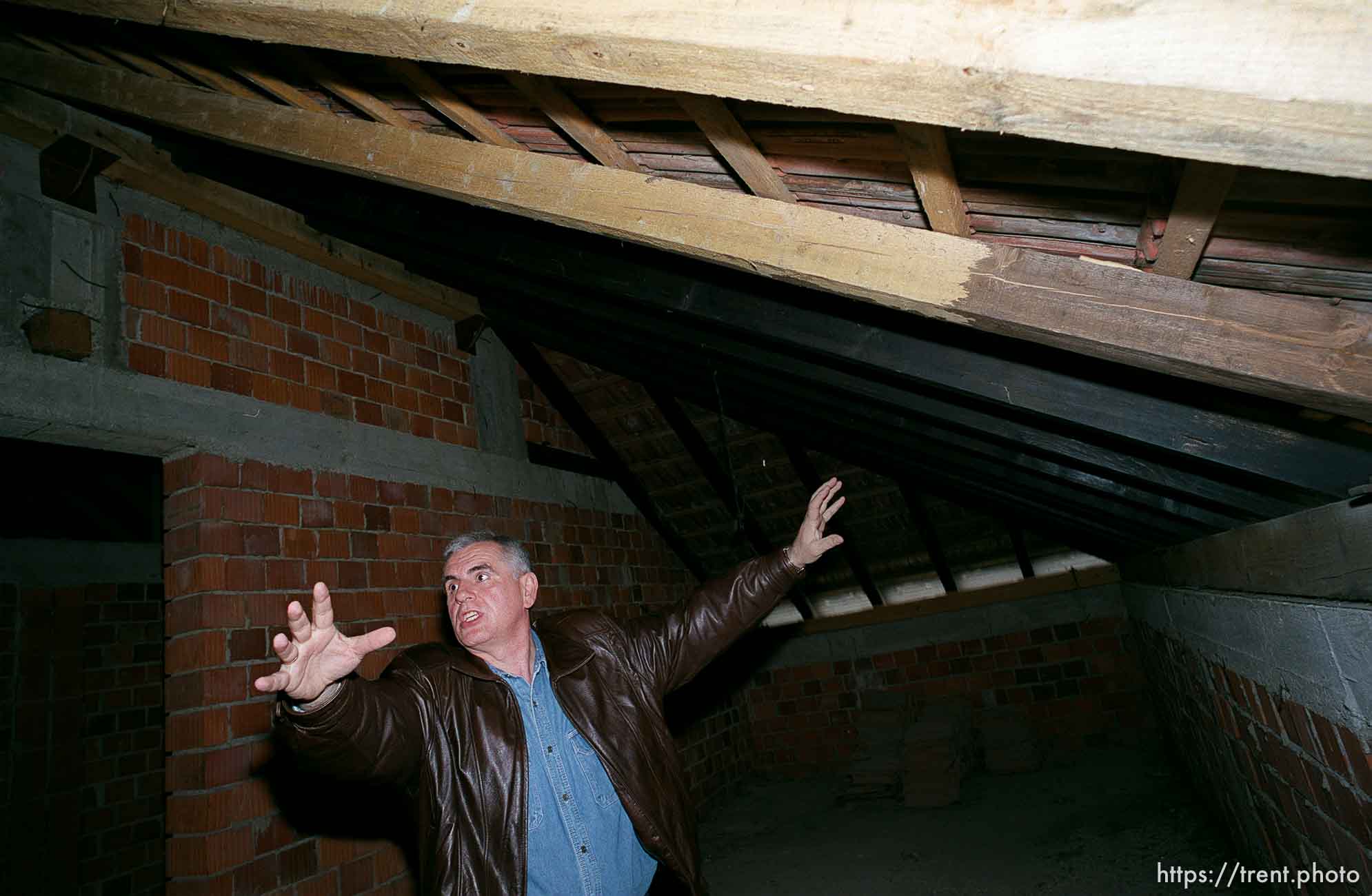 Redzo Kurbegovic shows where Serb grenades and shells came into his attic.