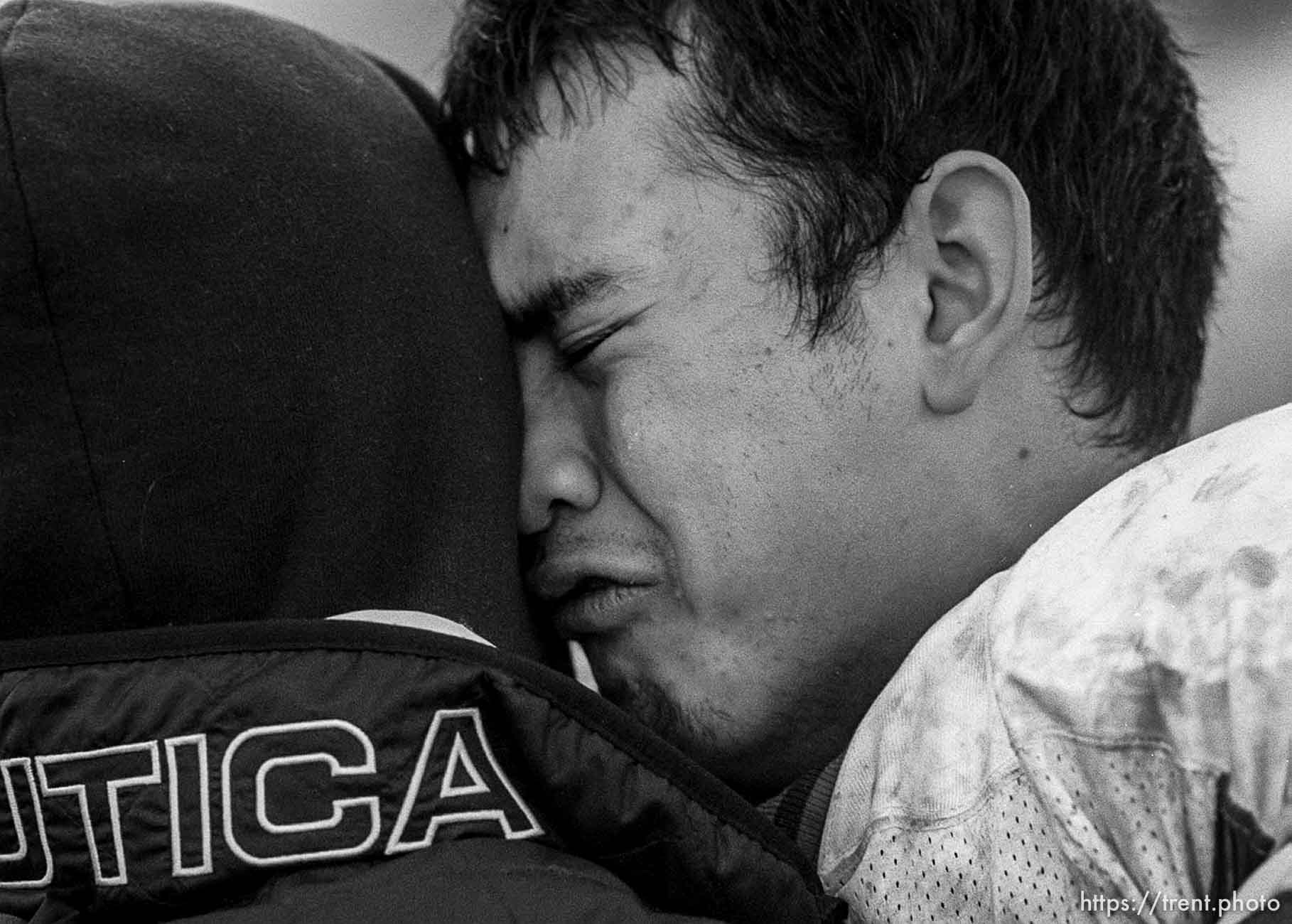 Northridge's Ali Prathan, emotionally and physically drained, embraces a friend at the end of the game as Northridge defeats Skyline to put an end to Skyline's streak of five state football championships Friday afternoon in Ogden. photo by Trent Nelson. 11/17/2000