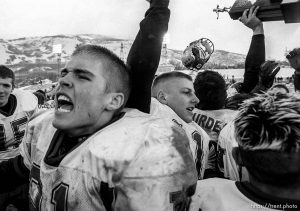 Northridge high school football players celebrate and hold aloft their championship trophy as Northridge defeats Skyline 44-29 to put an end to Skyline's streak of five state football championships Friday afternoon in Ogden. photo by Trent Nelson. 11/17/2000