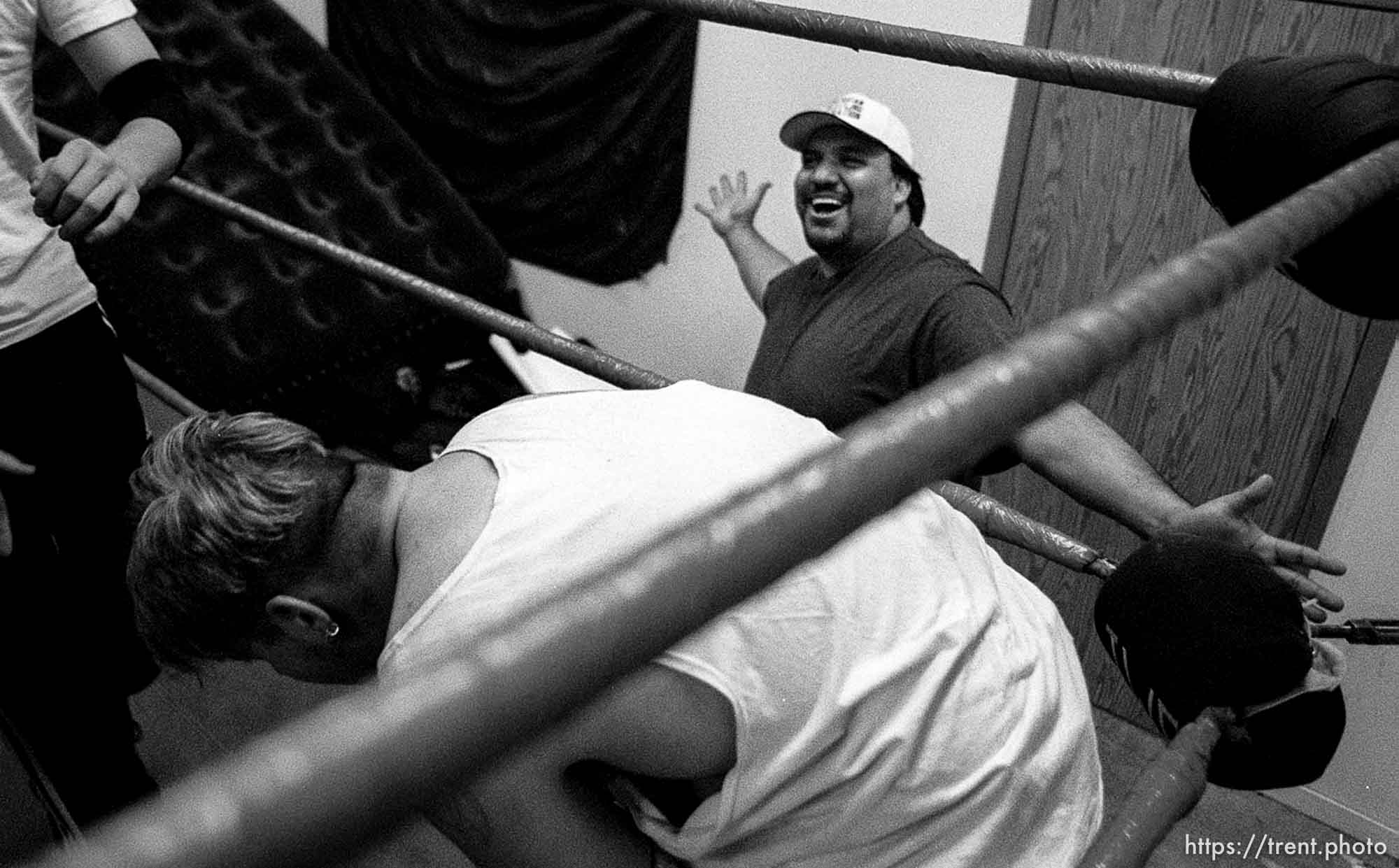 Steve Gatorwolf (rear) expresses his satisfaction with the action in the ring as wrestling hopefuls work on their moves in a practice match at the professional wrestling school in Orem. photo by Trent Nelson. 11/29/2000