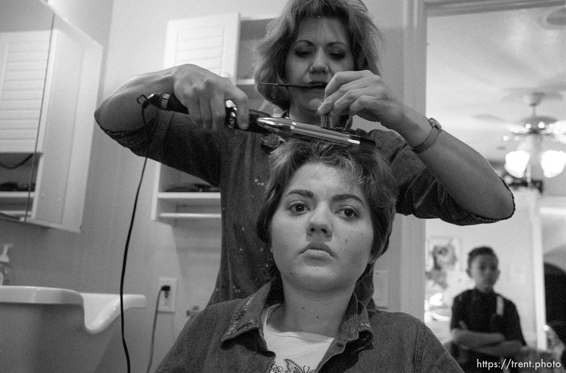 Sharon Salisbury gets her daughter Michelle ready for school. In the background is Josh, Sharon's adopted son.