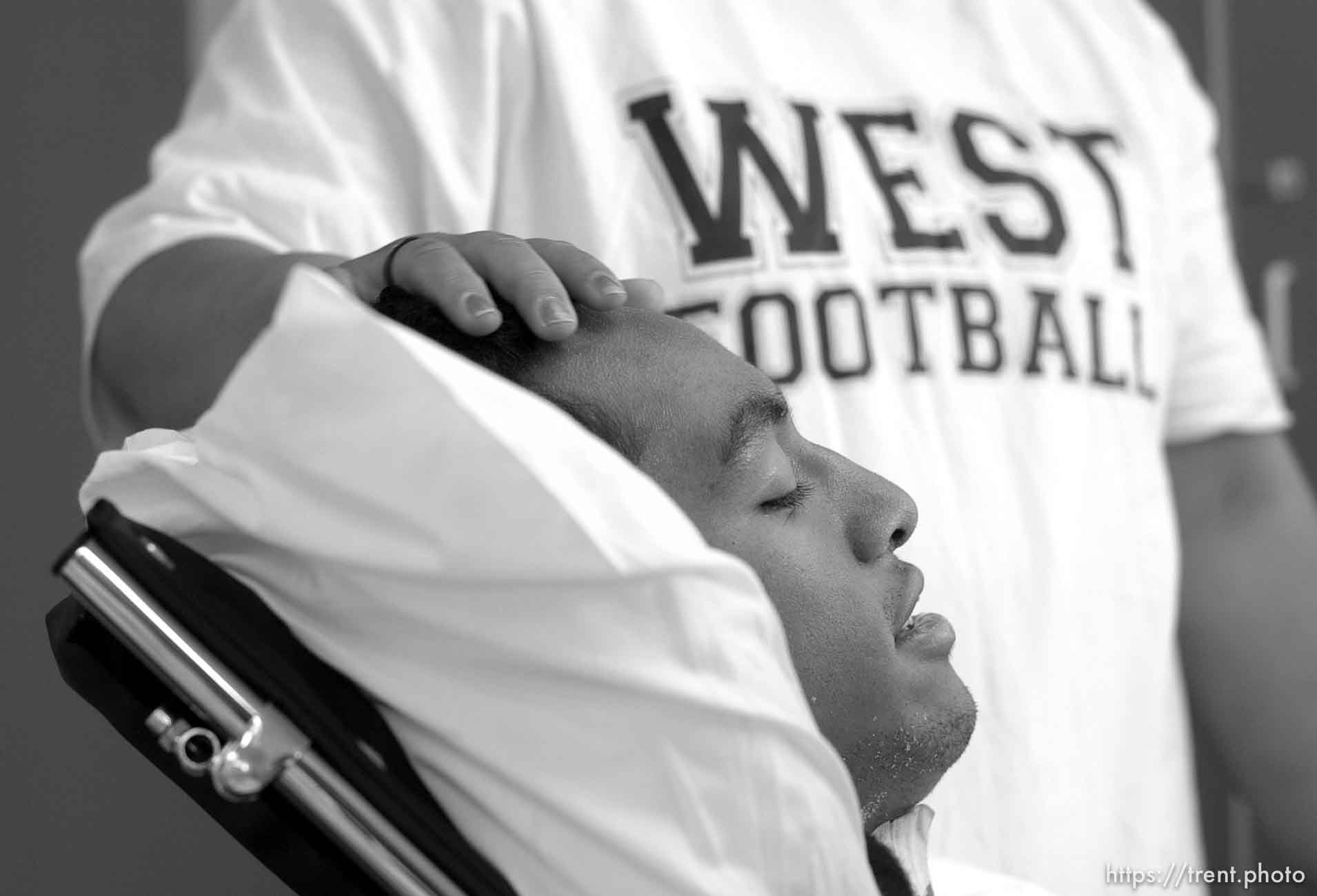 Una Taufa sits in a wheelchair while his sister Ola Taufa rubs his forehead. West High football player Una Taufa suffered a severe neck injury in a game two weeks ago and is partially paralyzed. He has begun the long and arduous rehabilitation process at LDS Hospital.
. 09/27/2001, 11:33:50 AM