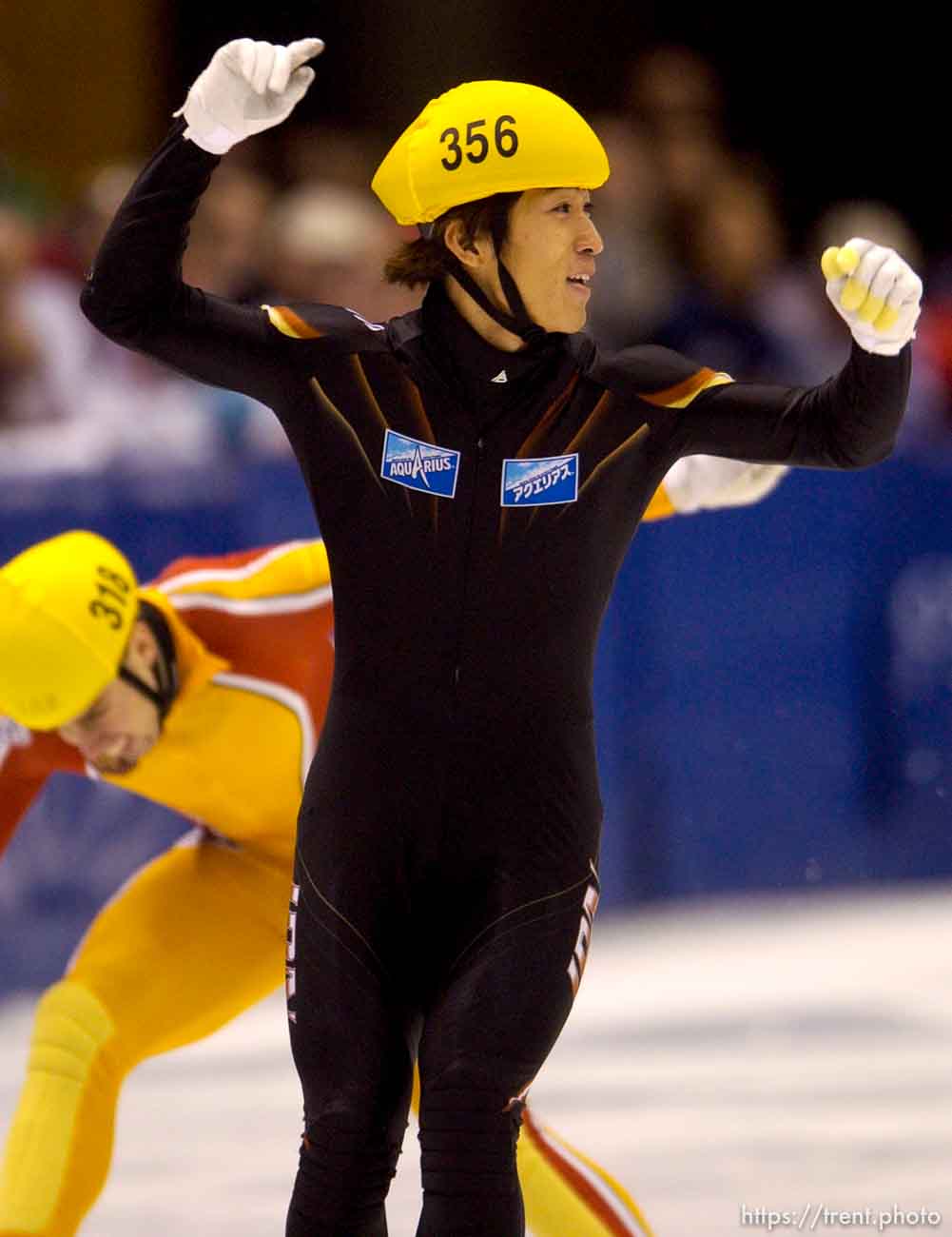 Japan's Takafumi Nishitani celebrates his first place in the 500 meter finals, Short Track Olympic Qualifier at the Delta Center Friday night. Behind him is 3rd place finisher, Canada's Eric Bedard.
. 10/26/2001, 8:44:32 PM