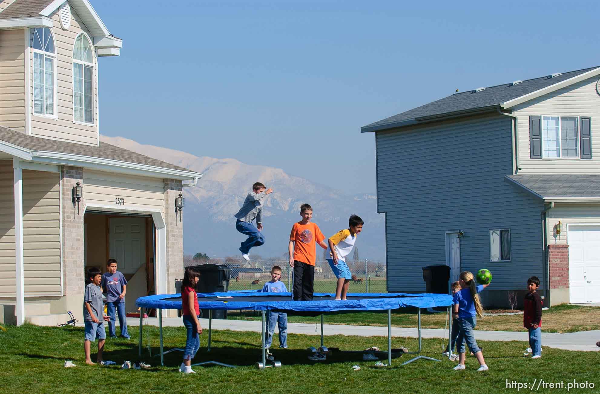 kids on trampoline in suburban homes and farmland. Davis County project. 04/06/2005