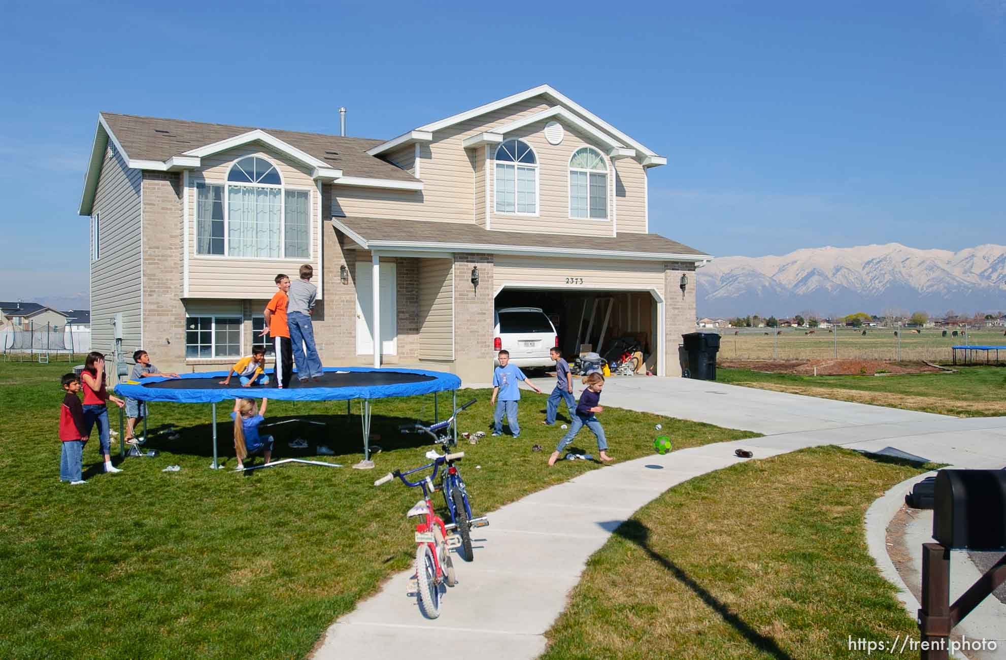 kids on trampoline in suburban homes and farmland. Davis County project. 04/06/2005