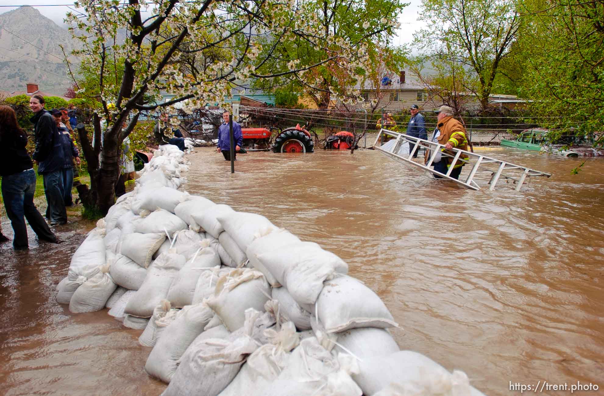 Volunteers work to save the Brigham City home of Linda and Arlin Kay as rain and melting snowpack raise the levels of Box Elder Creek and the Logan River. flood