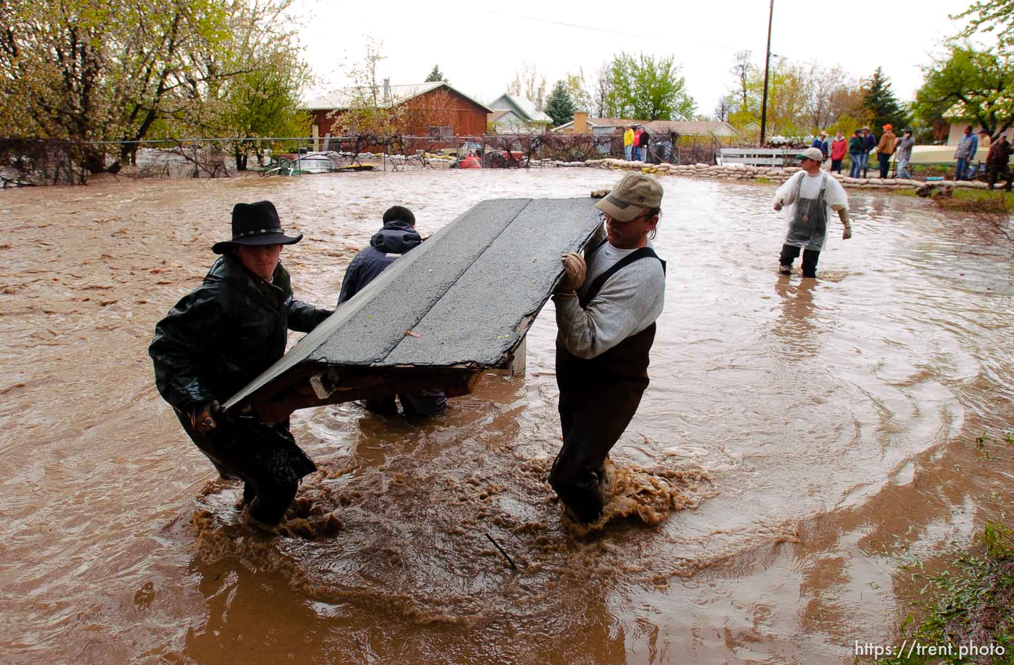 Volunteers work to save the Brigham City home of Linda and Arlin Kay as rain and melting snowpack raise the levels of Box Elder Creek and the Logan River. flood