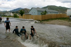 Kids playing in flood water. Flooding along 700 South in Tooele Tuesday.