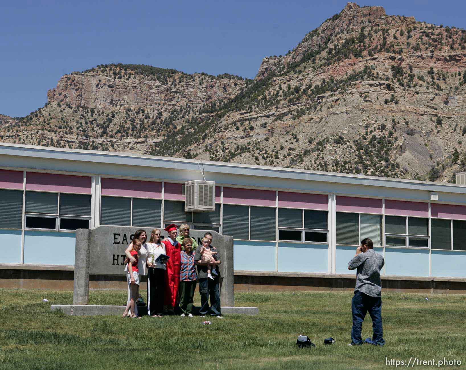 ECHS graduate Justin Ward has his photo taken with family members in front of the school and the Book Cliffs.