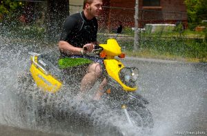 A man in a wetsuit riding a scooter through water several inches deep along 700 South in Tooele Tuesday. Water from Settlement Canyon Reservoir turned the street into a shallow river after the area had 3.7 inches of rain Monday.
Photo by Trent Nelson; 5.31.2005