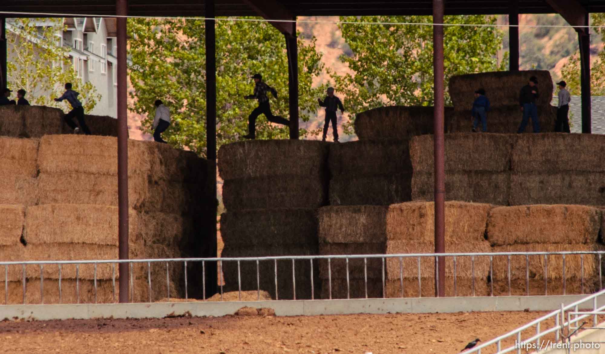 Boys leaping on hay bales, Colorado City