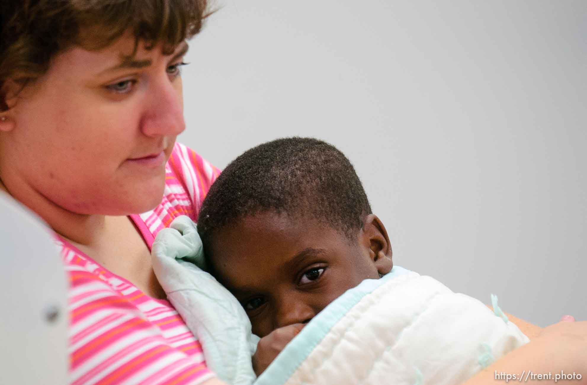 A young child in the arms of volunteer Carolyn Clark in the daycare center (Camp BeBe) at Camp Williams, where people who were evacuated from the hurricane Katrina disaster in New Orleans, are making a go of it.