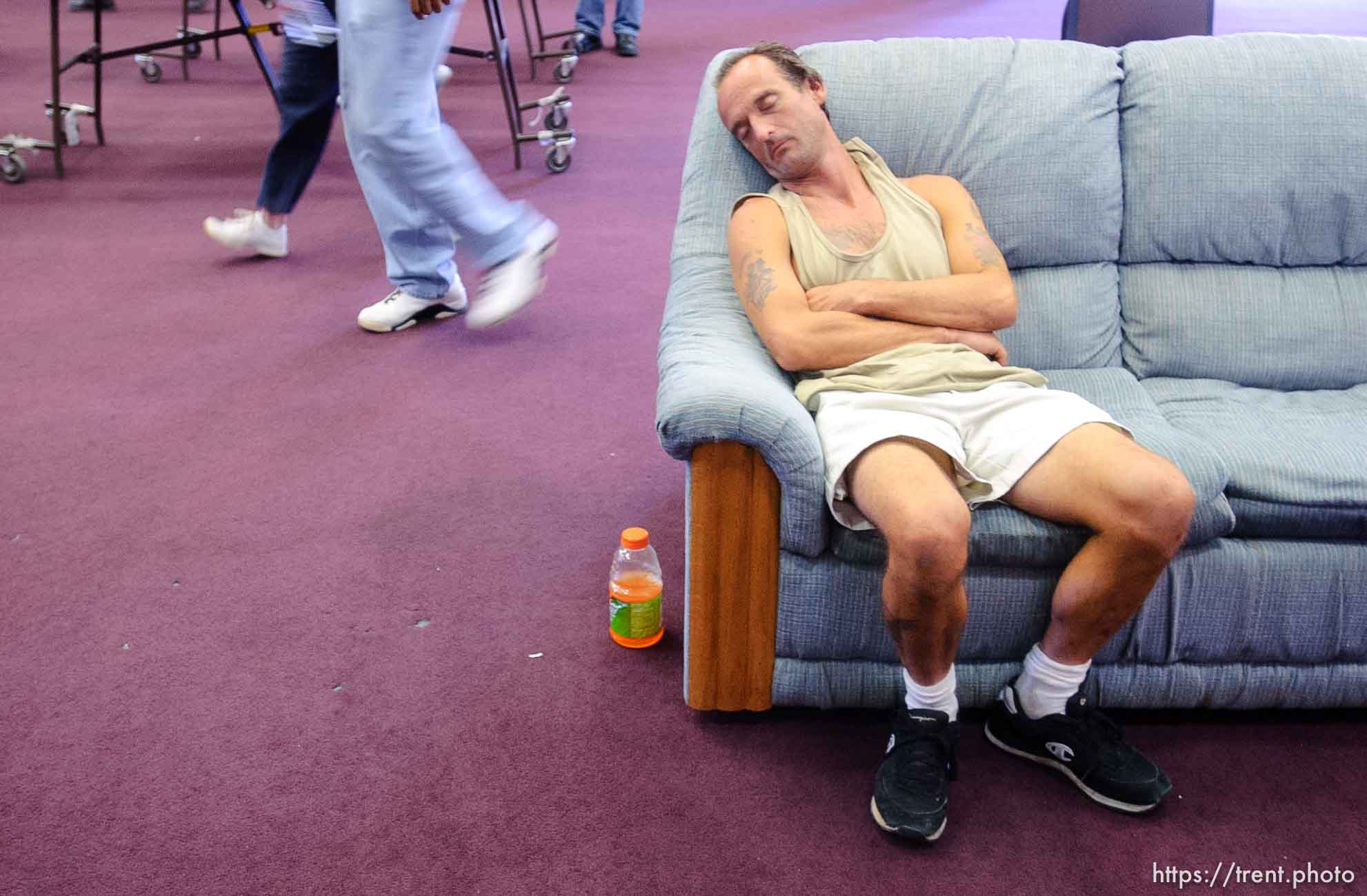 man asleep on couch at Camp Williams, where people who were evacuated from the hurricane Katrina disaster in New Orleans, are making a go of it.