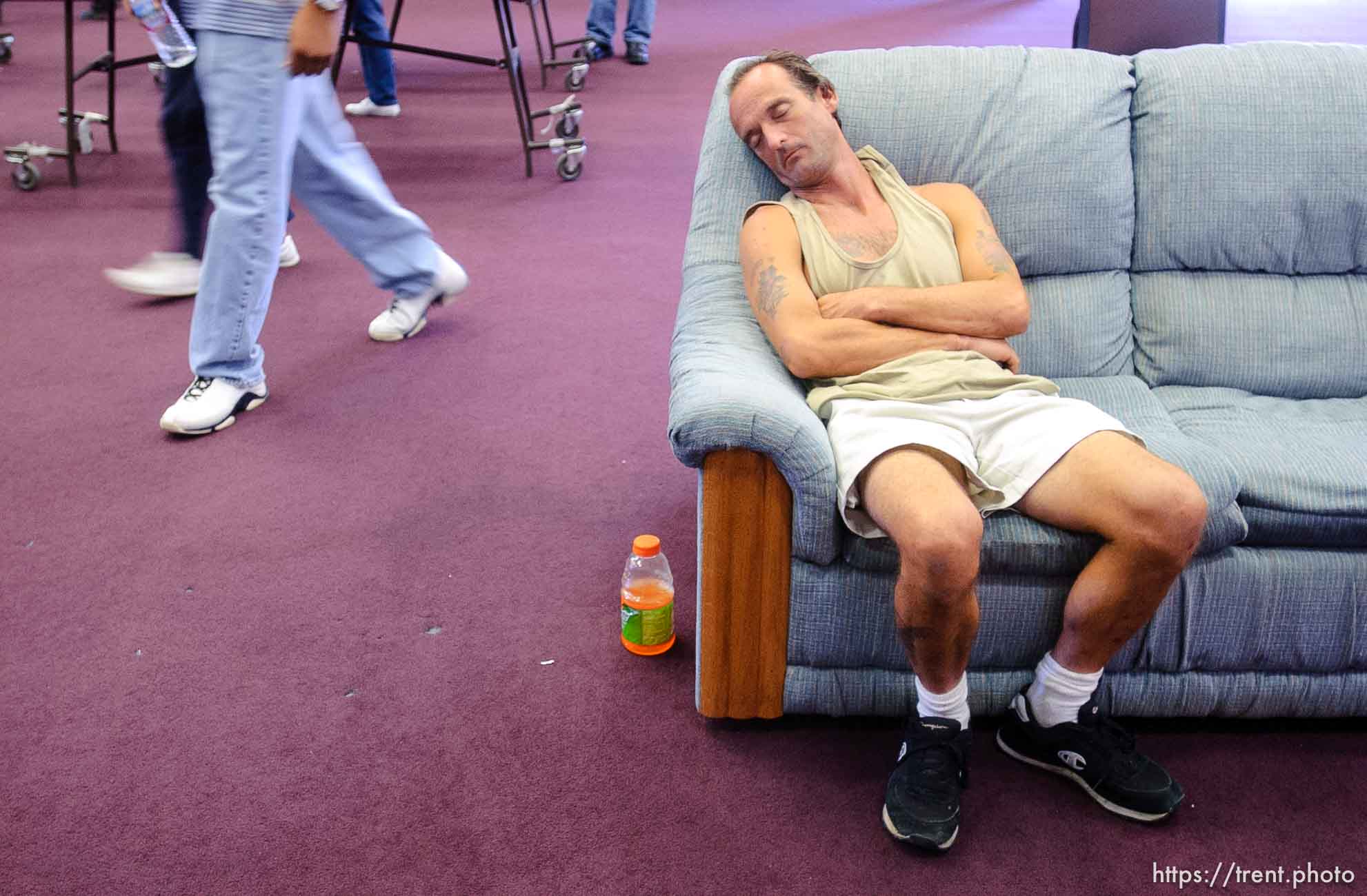 man asleep on couch at Camp Williams, where people who were evacuated from the hurricane Katrina disaster in New Orleans, are making a go of it.