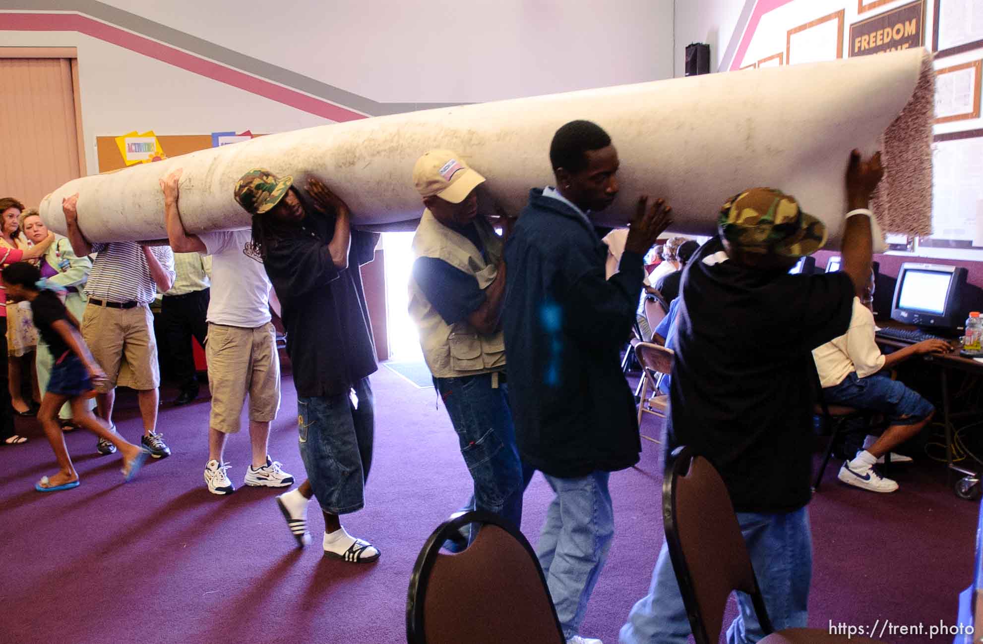 people bringing in donated carpet at Camp Williams, where people who were evacuated from the hurricane Katrina disaster in New Orleans, are making a go of it.