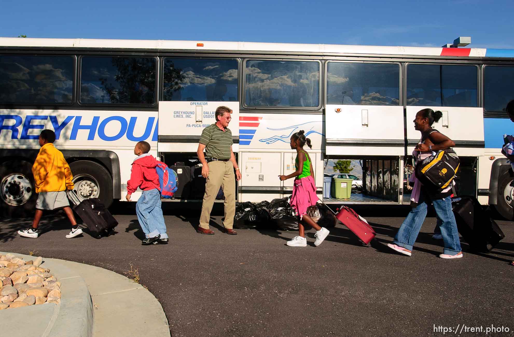 A family from New Orleans makes their way to a bus headed to Dallas and then Houston, Texas. About 100 of the 600 or so evacuees housed at Camp Williams boarded buses to Dallas, Texas Wednesday evening. From Dallas, they will make they way to a variety of locations and reunite with friends and family members.