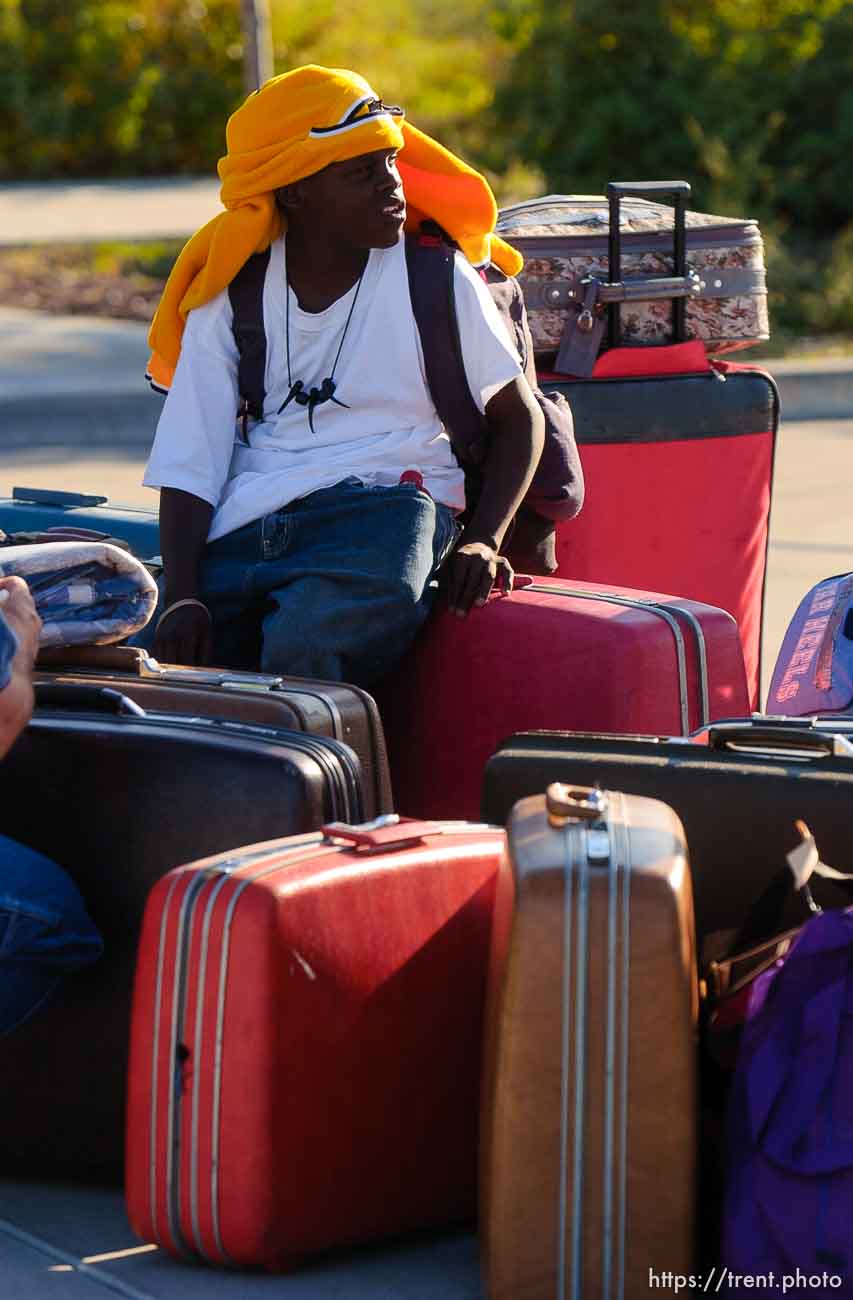 Alvin Price, of New Orleans, sits on his family's luggage as he waits to board a bus to Houston, Texas. About 100 of the 600 or so evacuees housed at Camp Williams boarded buses to Dallas, Texas Wednesday evening. From Dallas, they will make they way to a variety of locations and reunite with friends and family members.