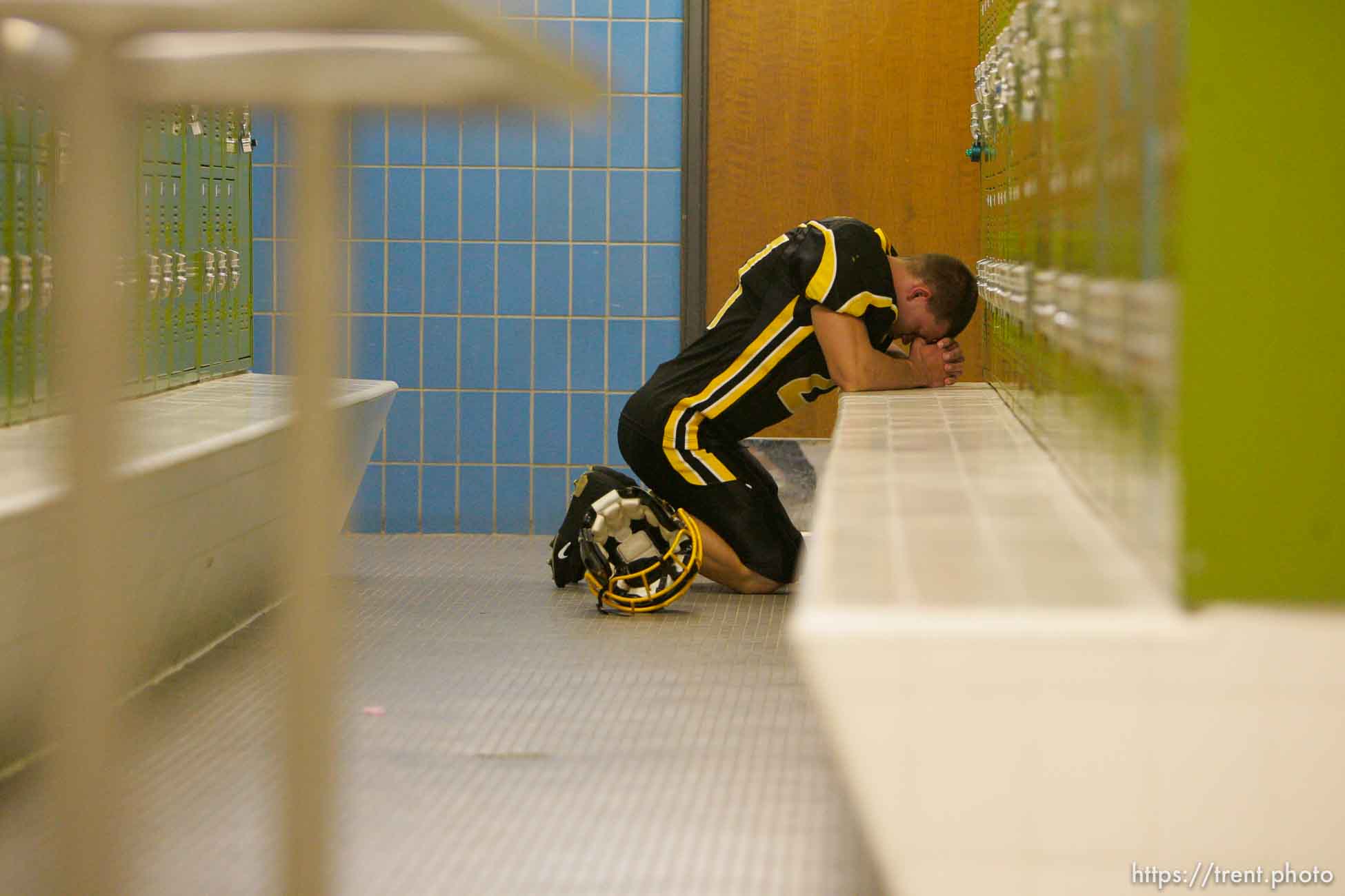 Cottonwood's Cody Williams prays pre-game in the locker room. Cottonwood vs. Highland high school football.