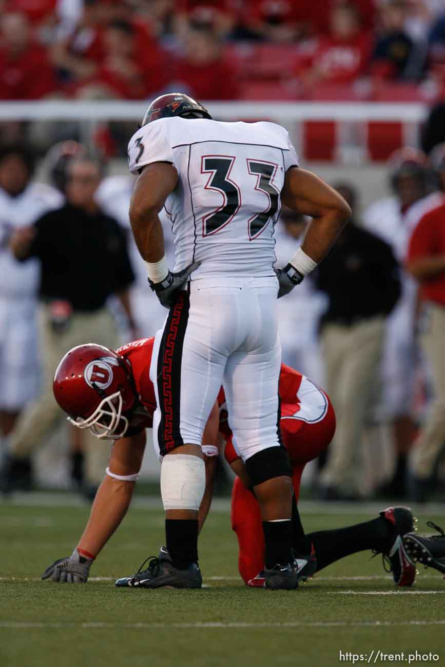 San Diego State's Freddy Keiaho stands over Utah receiver John Madsen after Keiaho tackled him. Utah vs. San Diego State University college football.