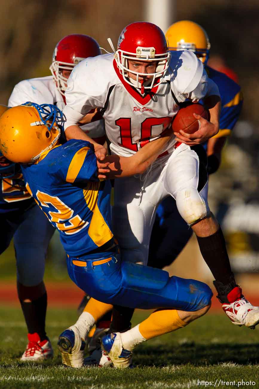 Grand quarterback Tony Dalton runs over San Juan's Dallin Shumway during a fake punt play, getting the first down. Grand vs. San Juan, 2A State Football Championship game at Southern Utah University's Eccles Coliseum in Cedar City.