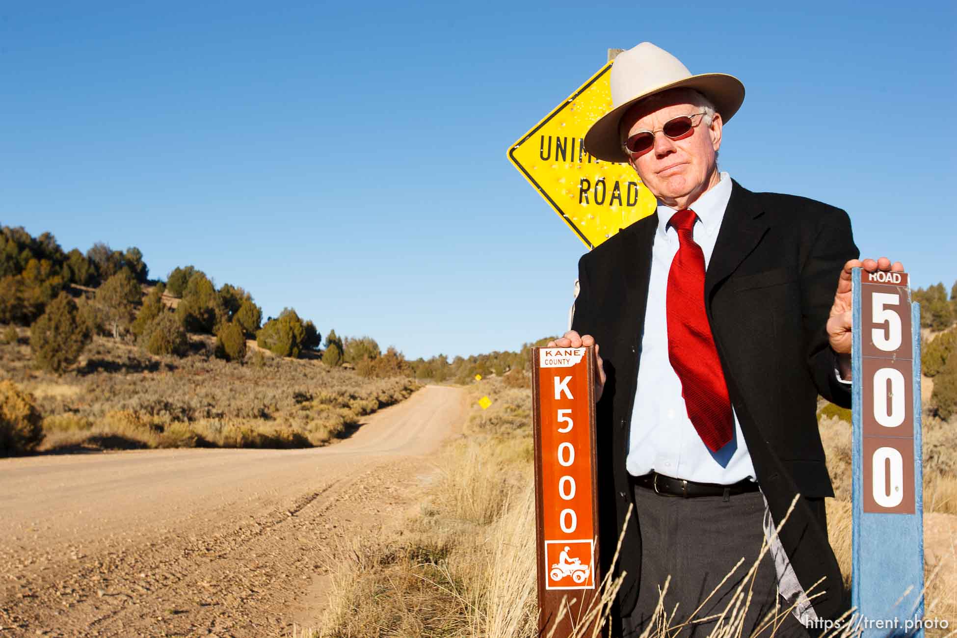 Kane County Commissioner Mark Habbeshaw at the intersection of Johnson Canyon Road and Skutumpah Road in the Grand Staircase National Monument, where the BLM and Kane County have placed conflicting signs. Kane County's sign (on left) indicates OHV/ATV access, which the BLM disputes.