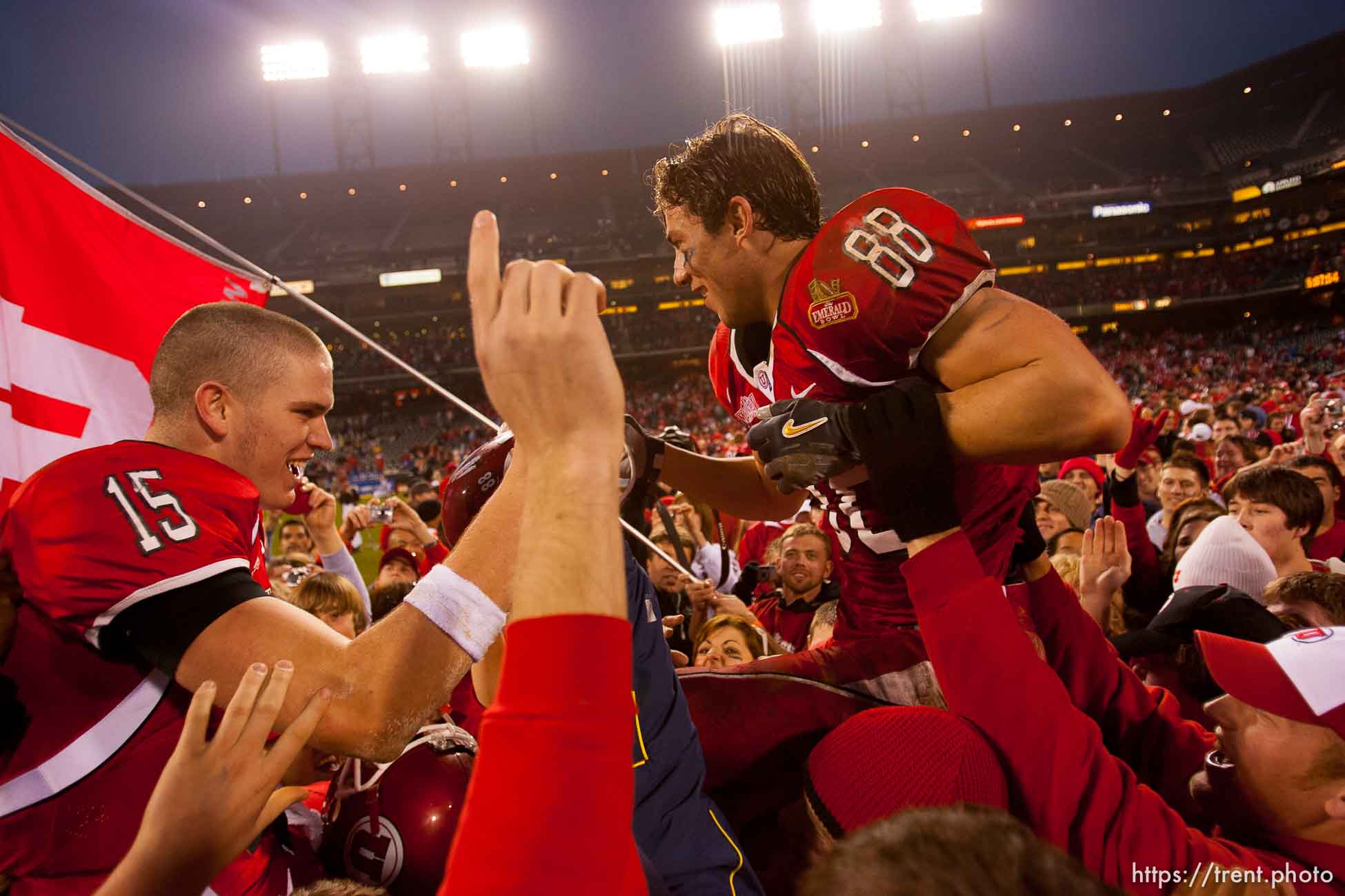 Utah quarterback Brett Ratliff and Travis LaTendresse (right) are lifted up by fans after the win. University of Utah vs. Georgia Tech, Emerald Bowl, San Francisco.