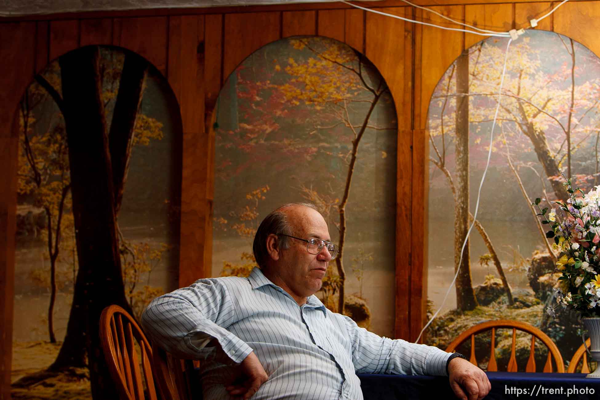 Isaac Wyler in his home with portraits of his 34 children