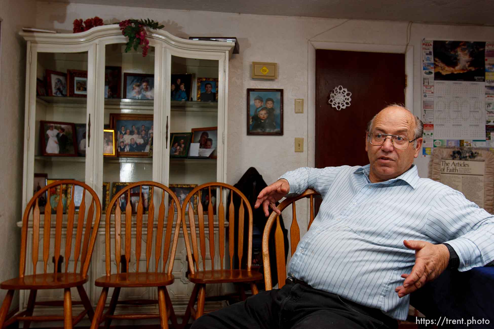 Marvin Wyler in his home with portraits of his 34 children