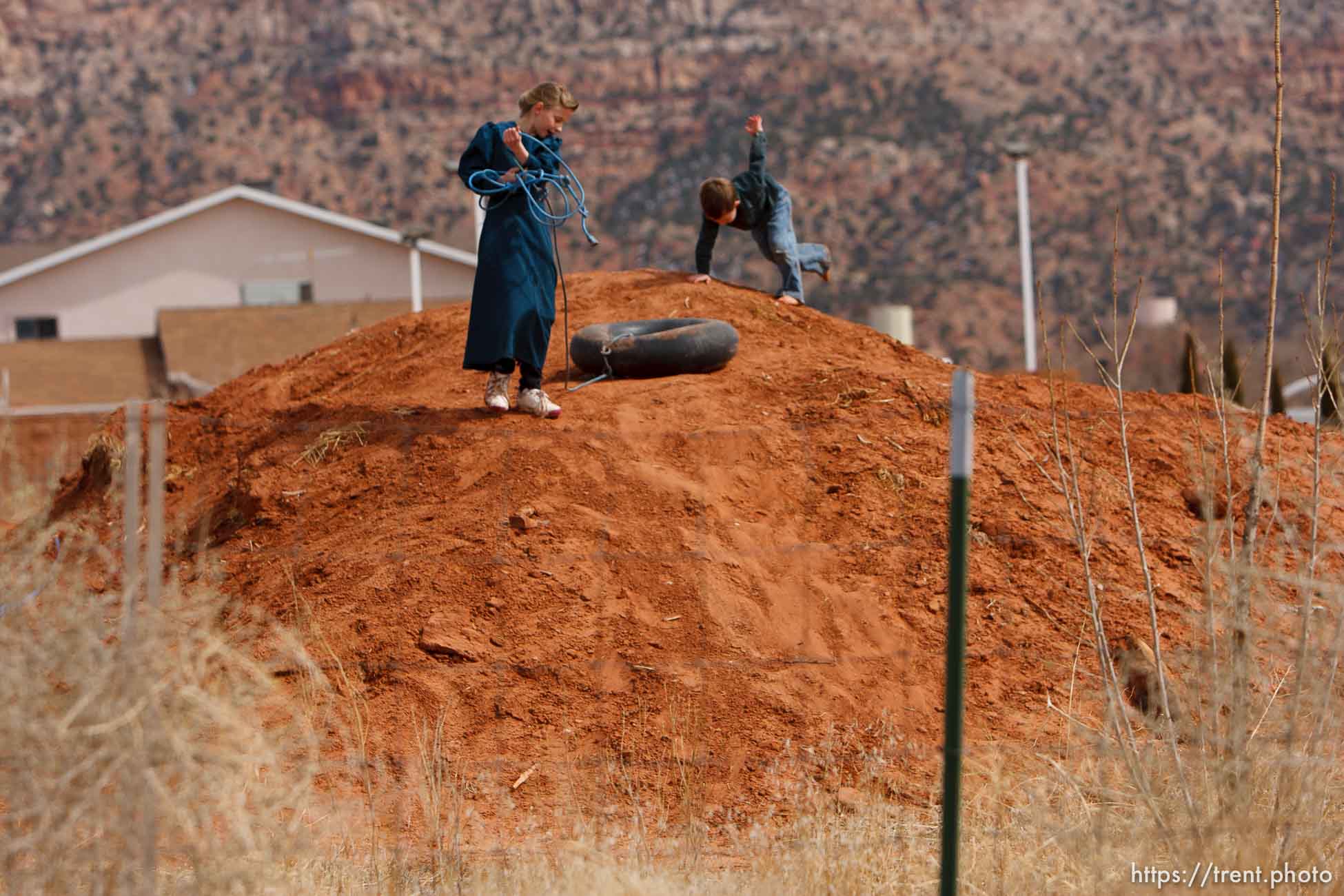 kids playing on mound of red dirt