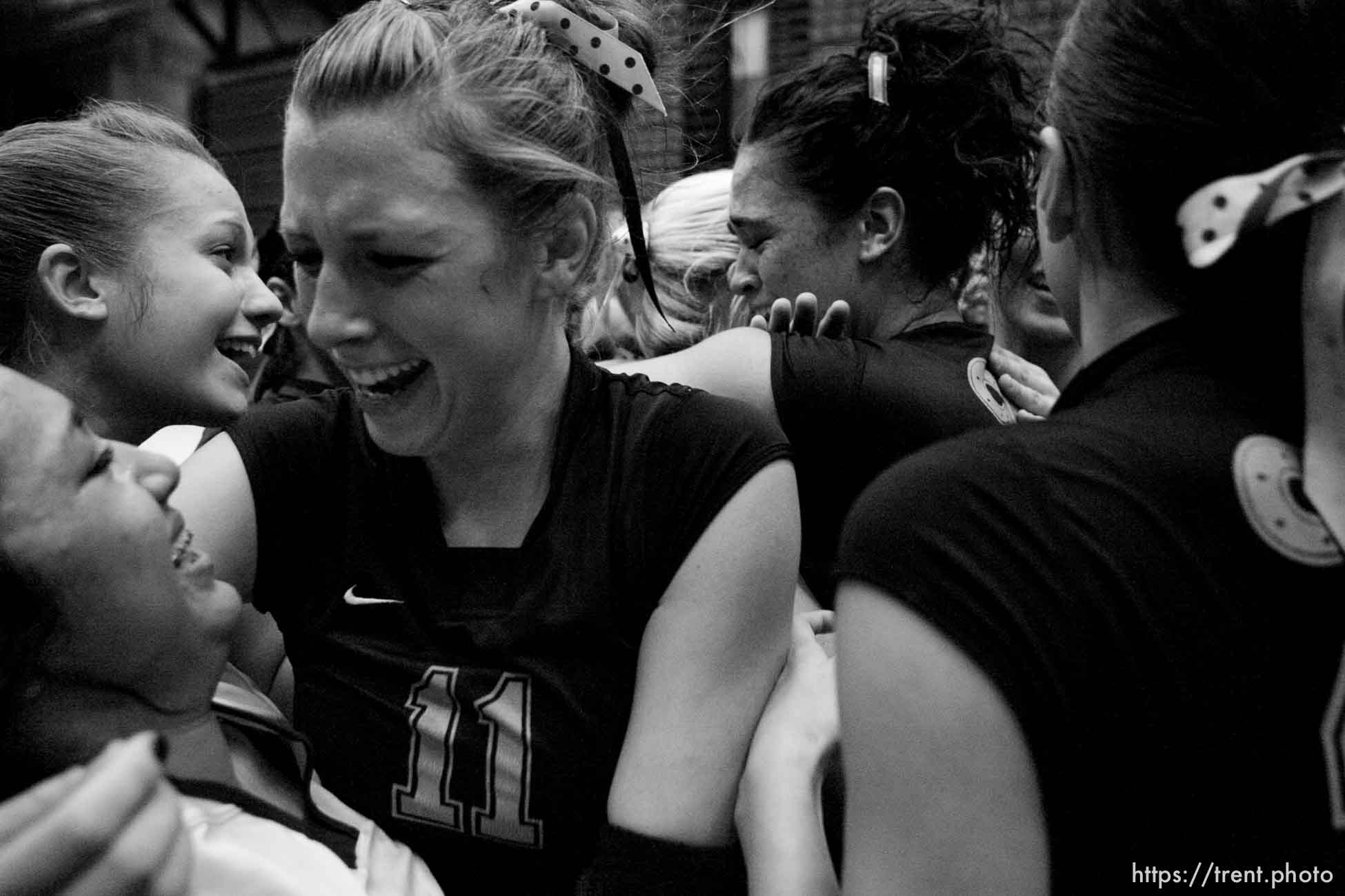 Orem - Cottonwood's Kylie Hudson (center) hugs teammate Trustine Mendoza as the team celebrates their state championship. Cottonwood defeats Murray for the 4A state championship, girls high school volleyball at UVSC.