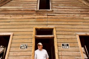 Ophir - Ophir Mayor Walt Shubert and others are working to restore historic homes in this small scenic town. Shubert is pictured standing in the doorway of the historic Alt home, which was moved to Ophir from Mercur in 1930.