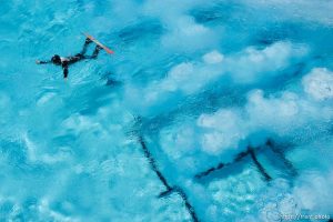 Park City - Graham Watanabe took advantage of a sunny day to practice aerials, snowboarding off the aerials jump and landing in the pool at the Utah Olympic Park. The air bubbles coming up from the bottom of the pool help soften the athlete's landing.