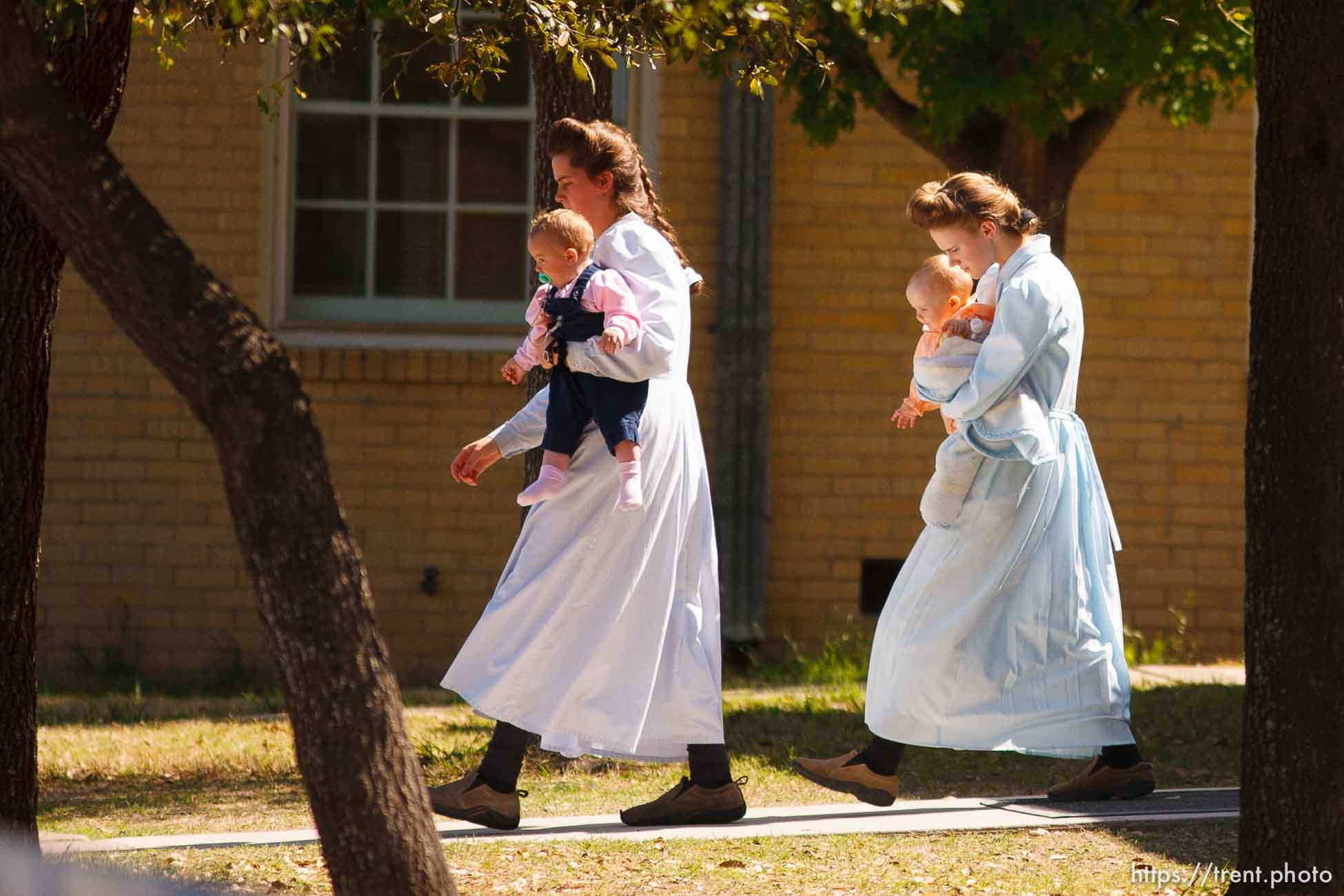 Eldorado - FLDS women and children from the YFZ Ranch are escorted by Texas Child Protective Services workers from the First Baptist Church's Fellowship Hall to waiting buses Sunday, April 6, 2008.