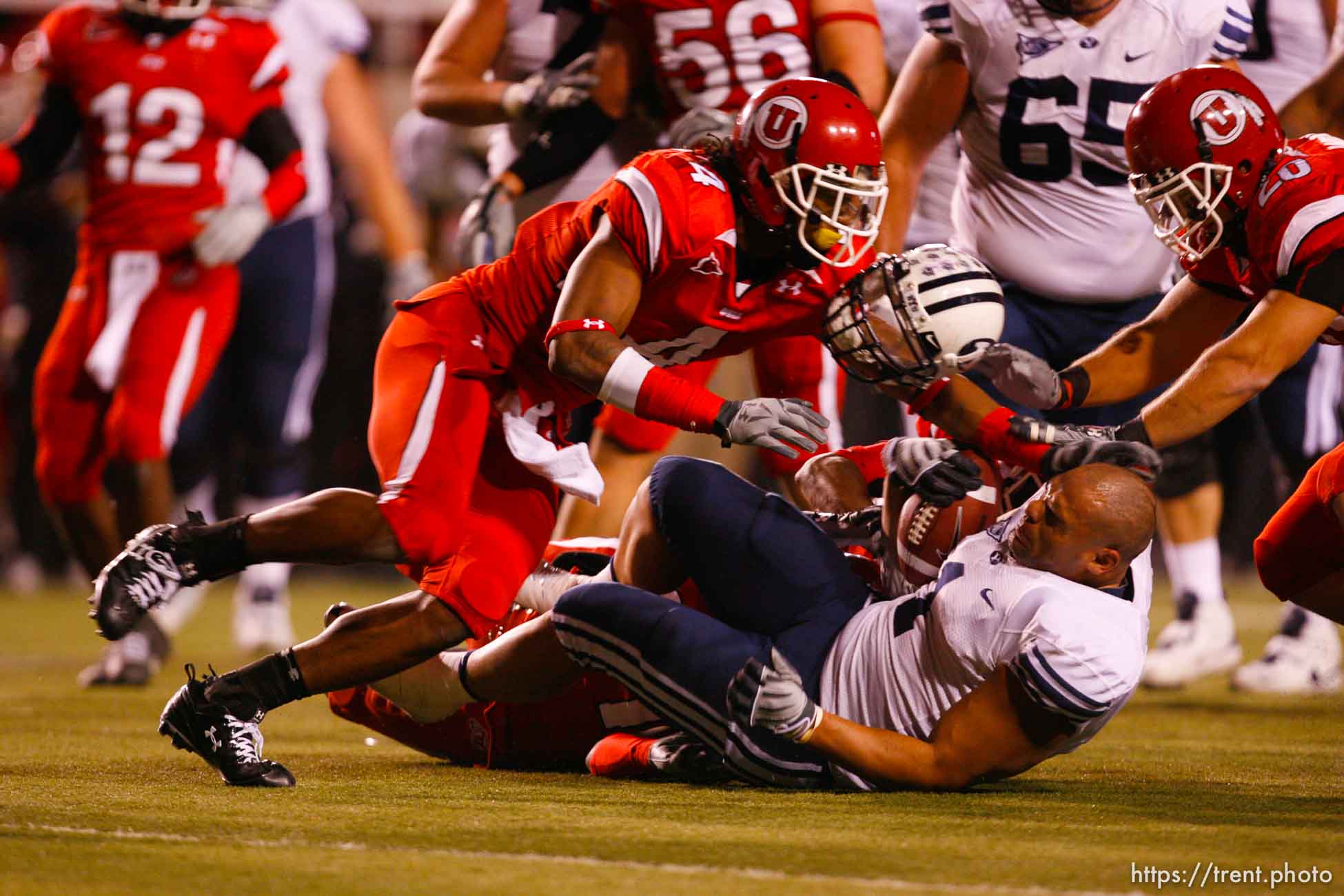 Salt Lake City - Utah vs. BYU college football Saturday, November 22, 2008 at Rice-Eccles Stadium. BYU RB Fui Vakapuna (1) tackled by Utah defensive back Terrell Cole (21), loses his helmet. Utah running back Matt Asiata (4)