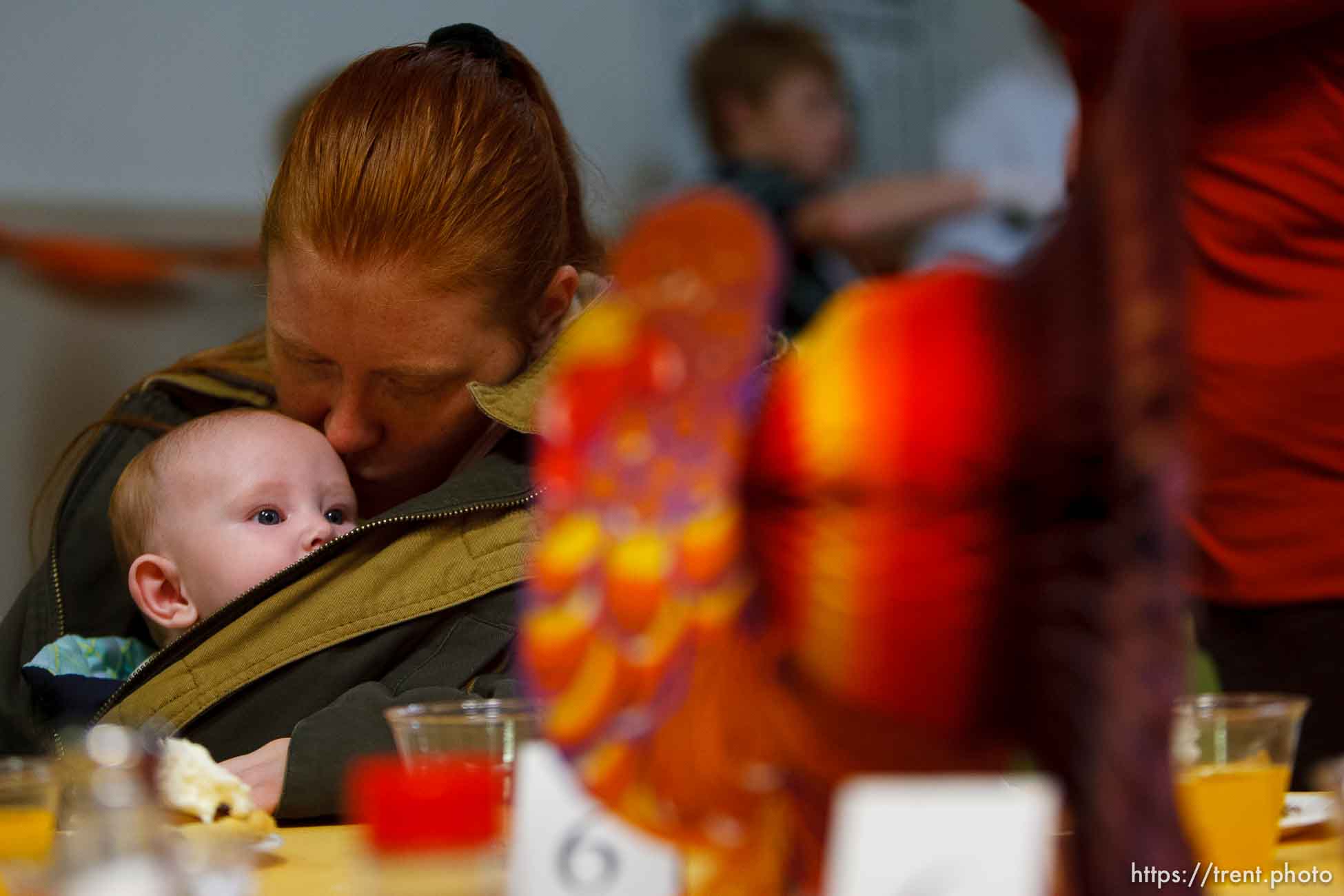 Salt Lake City - Melissa Wilson of West Jordan kisses her 5-month old daughter Kalya McBride at an early Thanksgiving. A large number of homeless and low-income individuals were served an early Thanksgiving feast at the Rescue Mission Tuesday November 25, 2008. In addition to a turkey dinner with apple, pecan, cherry and pumpkin pie, there were free flu shots, free haircuts and free backpacks. Tuesday November 25, 2008.