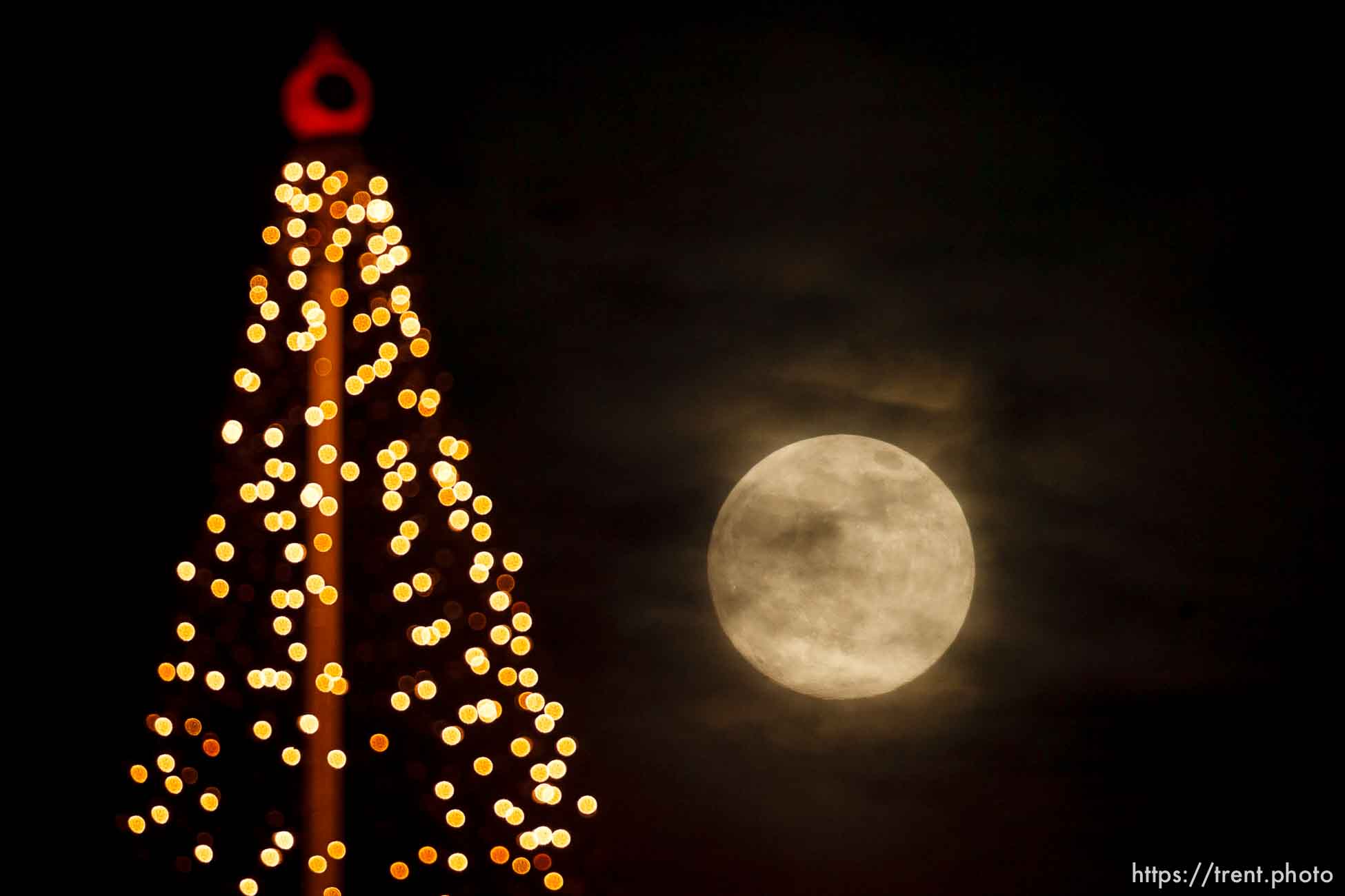 Salt Lake City - nearly full moon over a christmas tree display on a downtown high-rise, Thursday December 11, 2008.