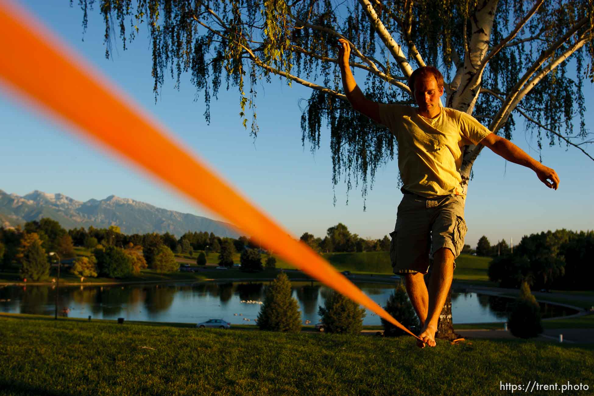 Salt Lake City - Matt Pallach works on his balance slacklining between two trees in SugarHouse Park Friday, July 17, 2009.