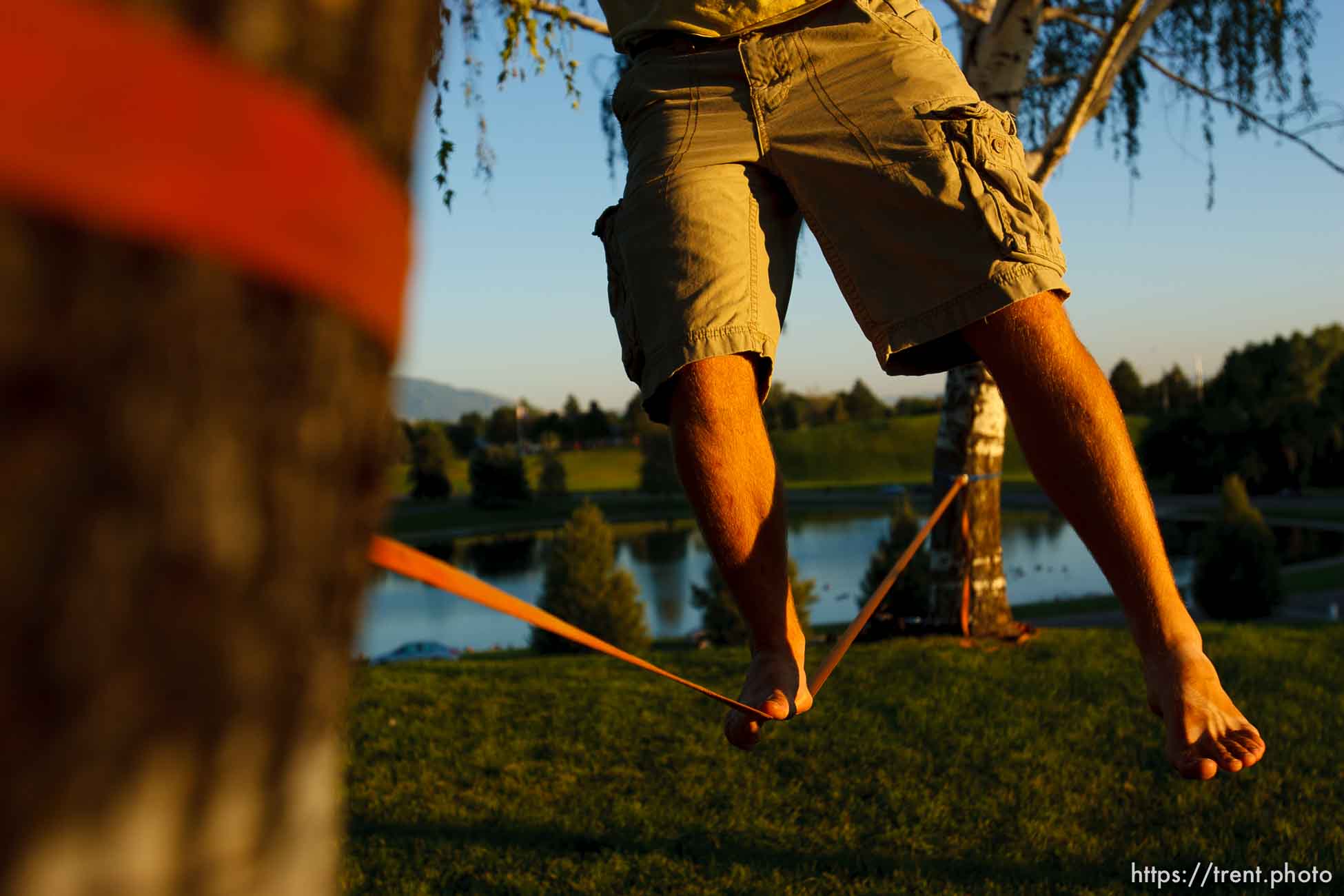 Salt Lake City - Matt Pallach works on his balance slacklining between two trees in SugarHouse Park Friday, July 17, 2009.