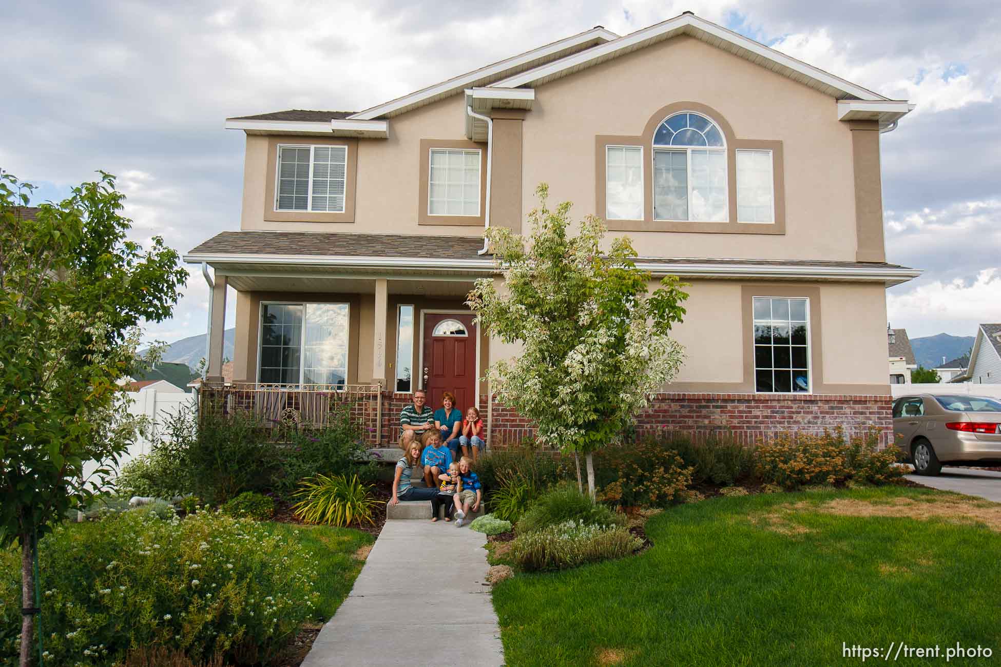 Trent Nelson  |  The Salt Lake Tribune
The Burton family on the front porch of their house Thursday, August 25, 2011. The Burton family are trying to sell their home in Tooele, Utah, due to a job transfer. Despite adding more than $20,000 in improvements since they purchased their home in 2005, they are now asking only what they paid for the home. In the back row, left to right: Scott, Angela and Kaitlyn Burton. Front row: Emily, Jeffrey, Zachary and Spencer Burton.