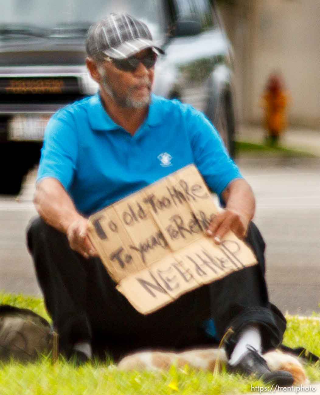 man with sign: too old to hire, too young to retire. need help