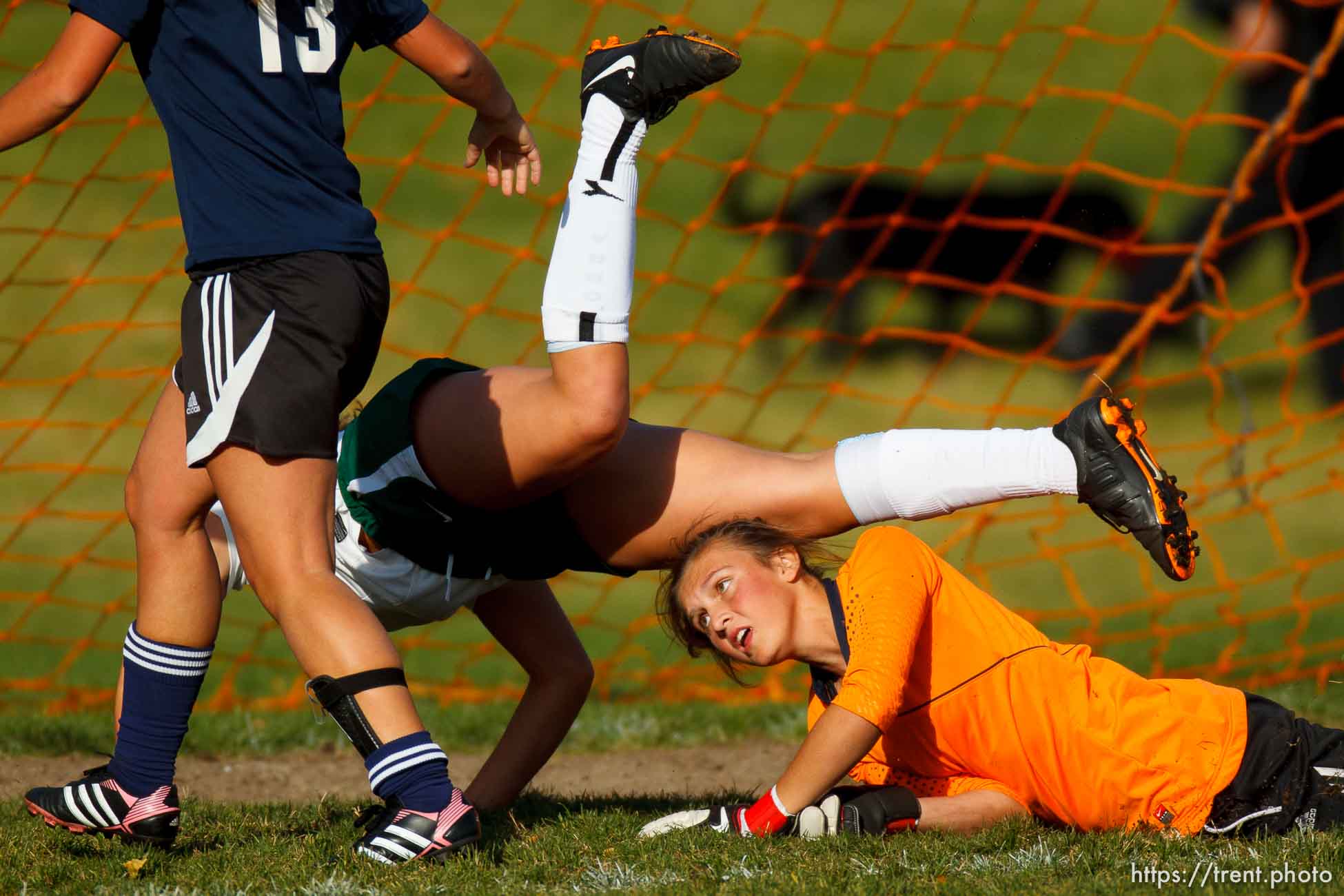 Trent Nelson  |  The Salt Lake Tribune
ALA goalkeeper Alexus Johnson dives for the ball, with Rowland Hall's Liz Baer diving over, as Rowland Hall faces American Leadership Academy in girls 2A high school soccer playoffs in Salt Lake City, Wednesday October 16, 2013.